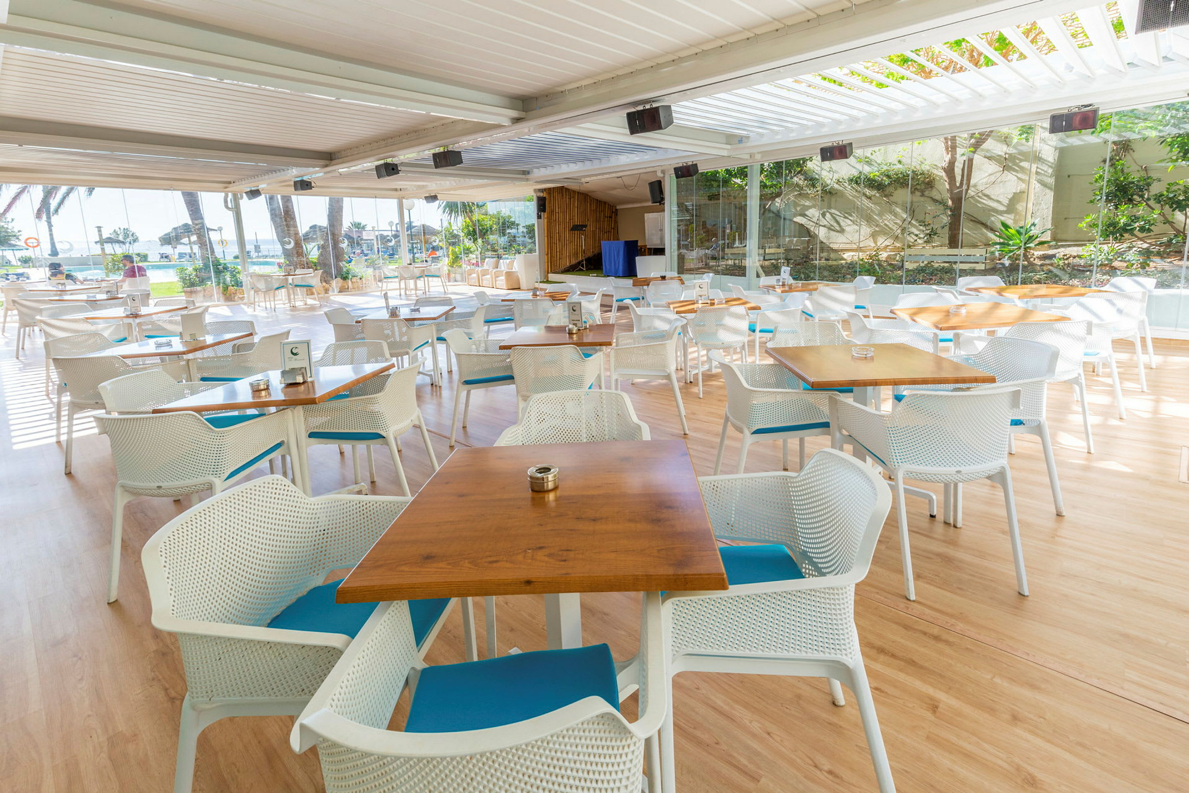 Ulkoterassi ravintola pöytineen ja tuoleineen panoraamaikkunoiden edessä. (Tekoälyn luoma teksti)