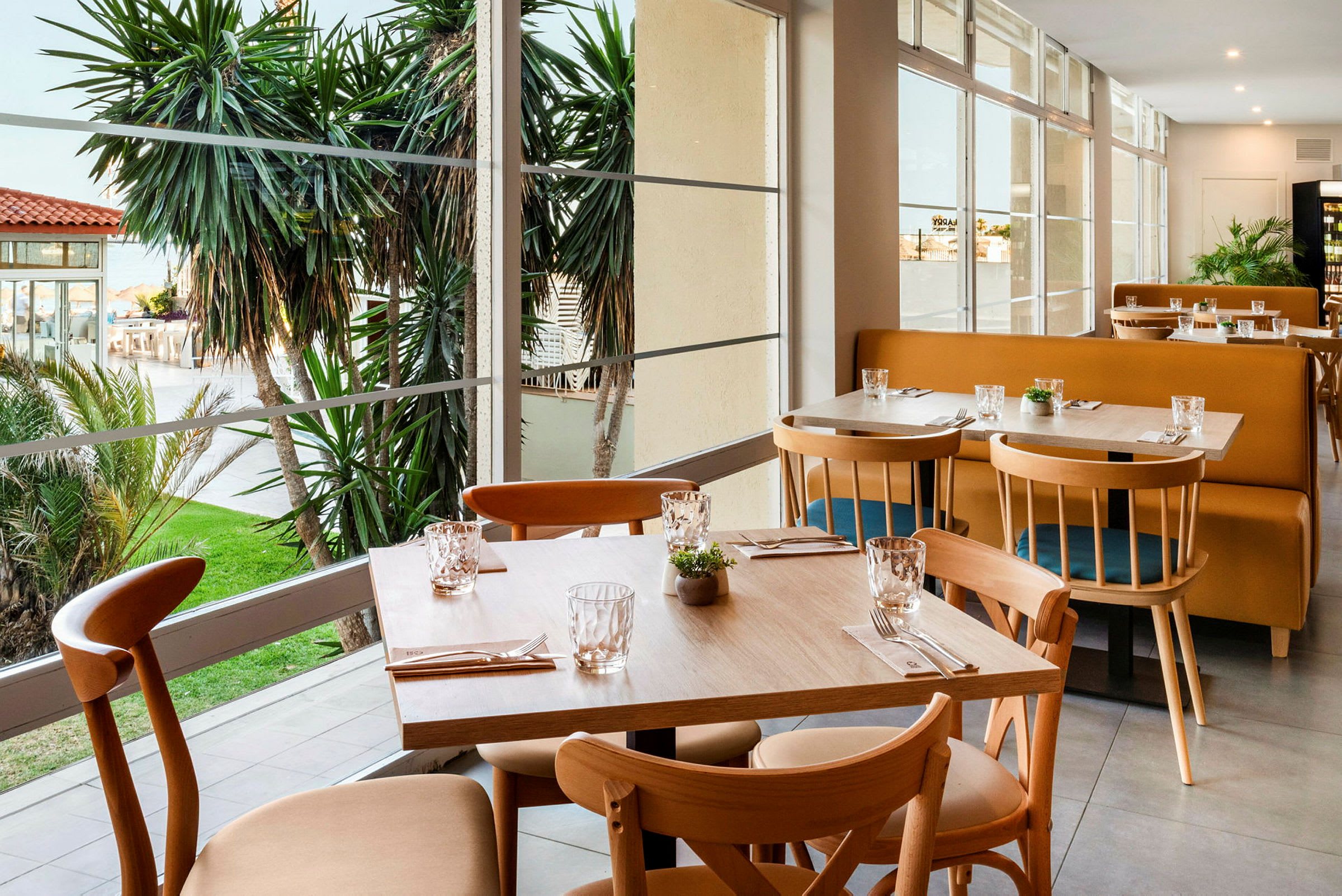 Ravintola, josta on näkymä puutarhaan ja palmuihin. (Tekoälyn luoma teksti)