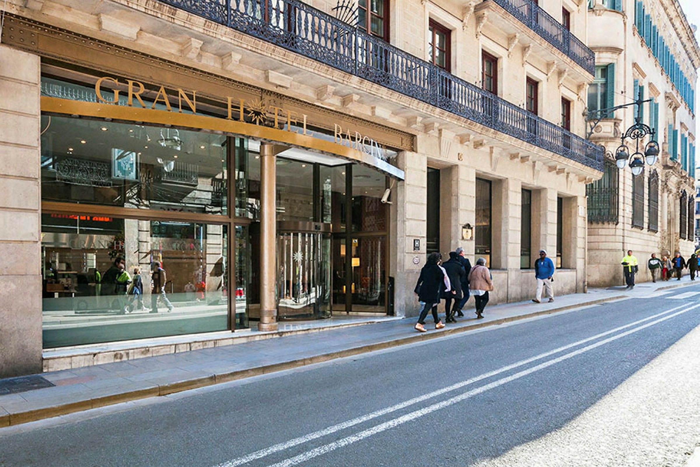 Katu, jossa on rakennuksia ja hotellin sisäänkäynti kyltillä "Gran Hotel Barcino". (Tekoälyn luoma teksti)