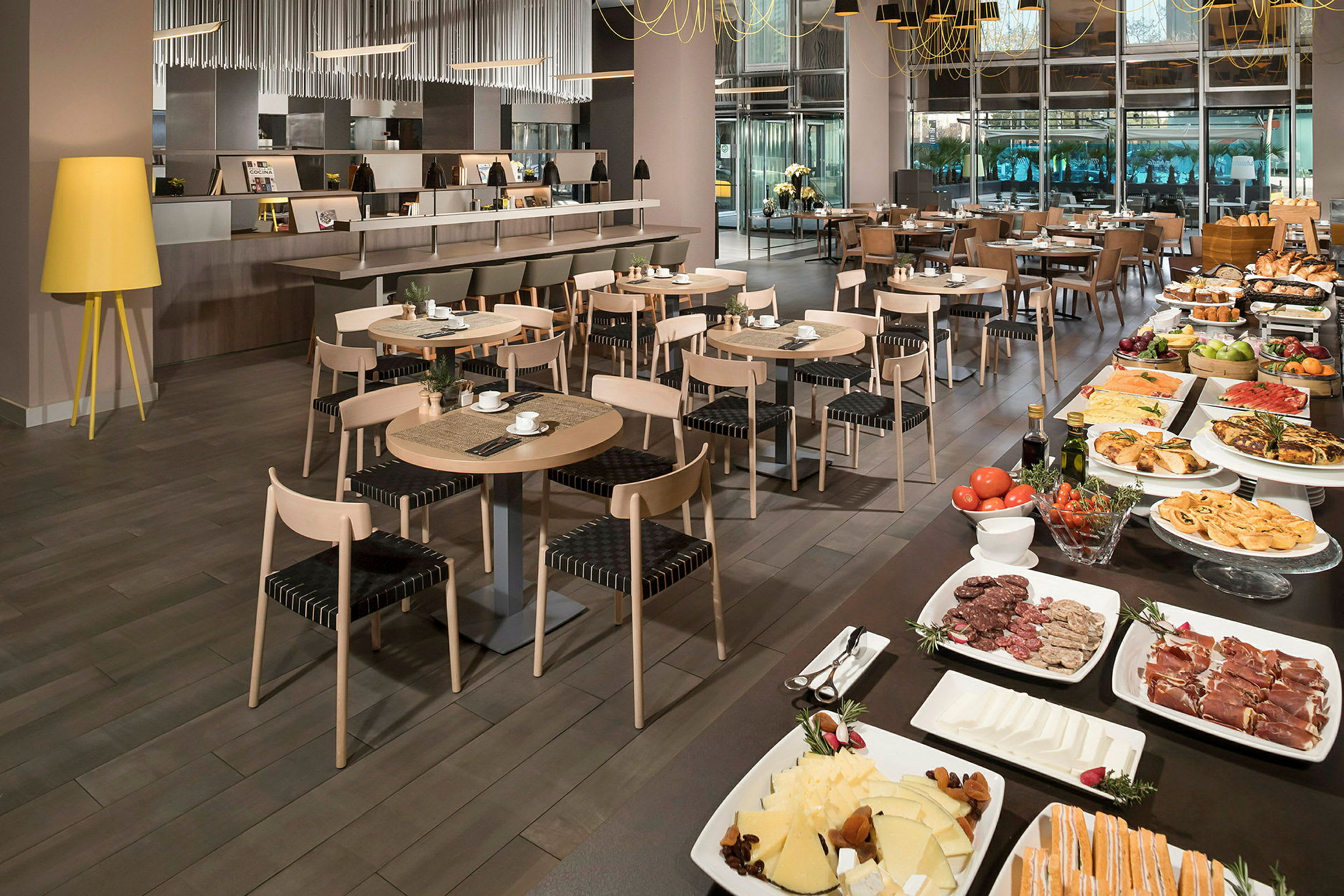 Moderni ruokasali, jossa on katettuja pöytiä ja runsas buffet eri ruokalajeilla. (Tekoälyn luoma teksti)