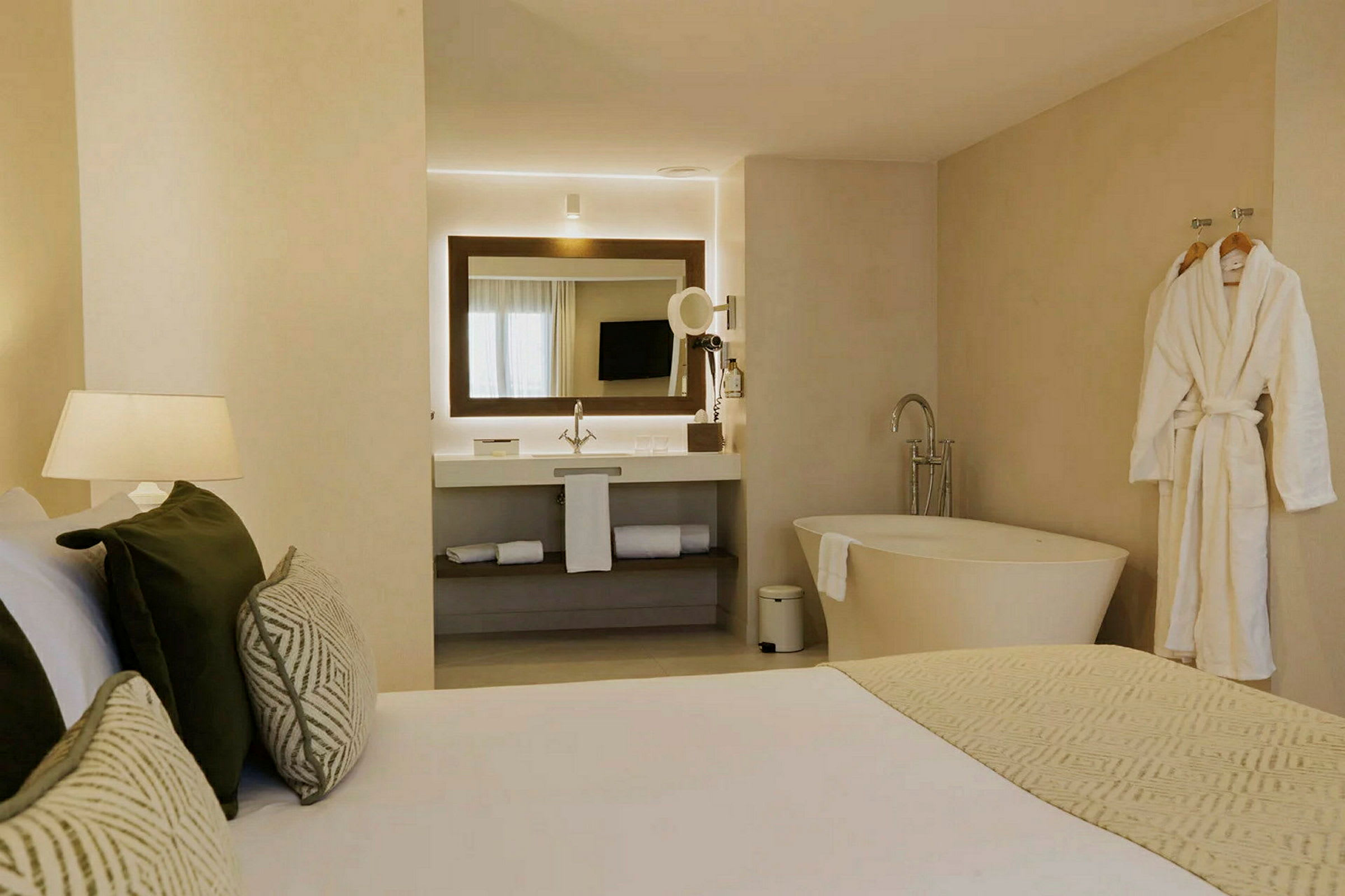 Moderni hotellihuone, jossa on kylpyhuone, sänky ja kylpyamme. (Tekoälyn luoma teksti)