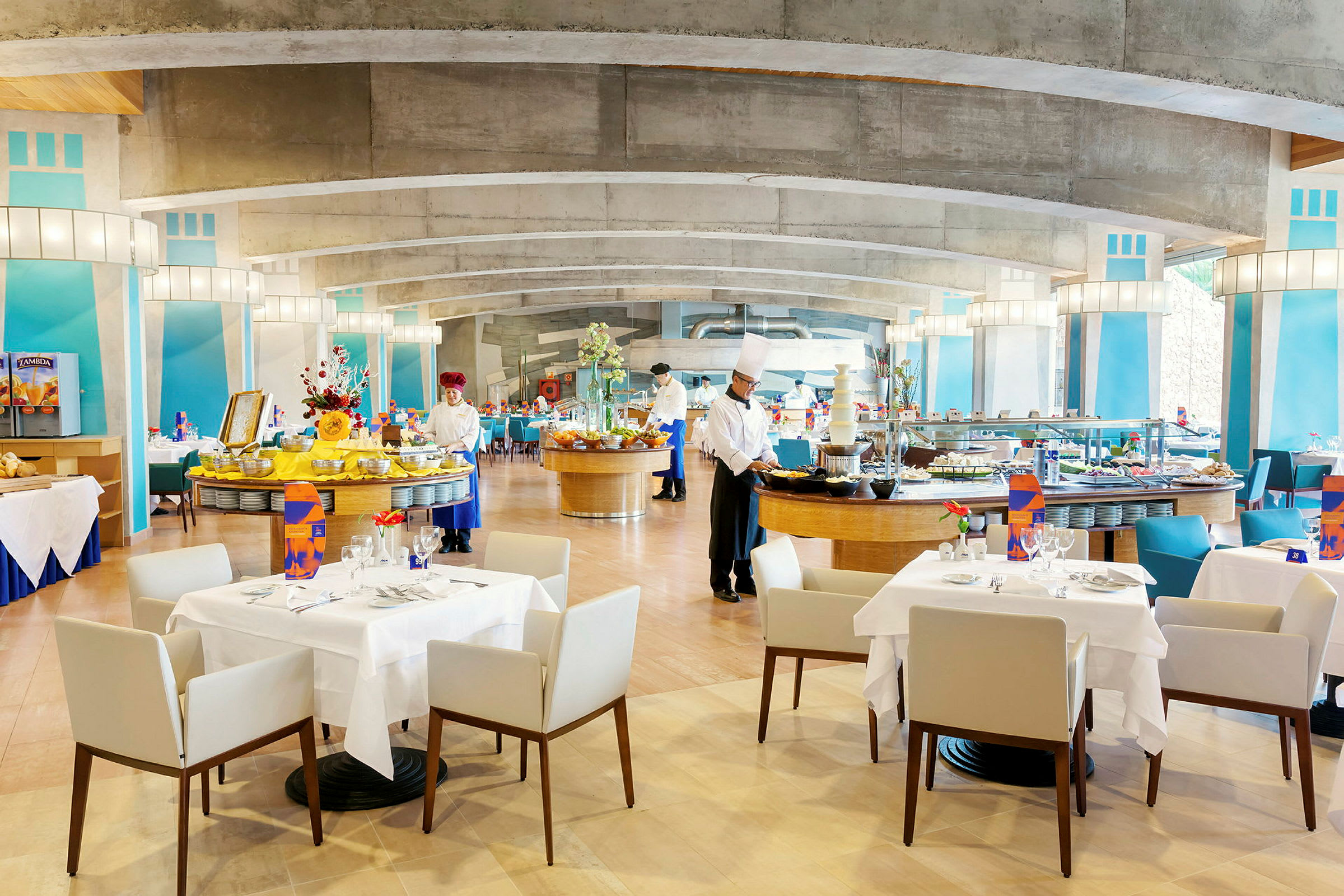 Ravintola, jossa on katettuja pöytiä ja buffet-alue, koristeltu värikkäillä yksityiskohdilla. (Tekoälyn luoma teksti)