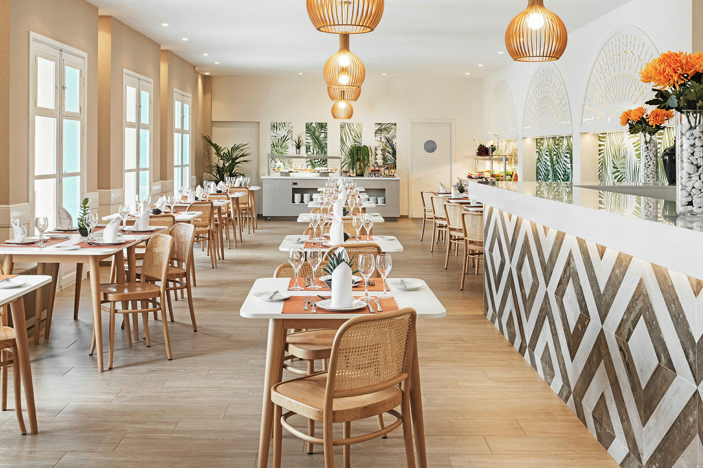 Moderni ravintola, jossa on puutuolit ja katetut pöydät, koristeltu kasveilla ja oransseilla yksityiskohdilla. (Tekoälyn luoma teksti)