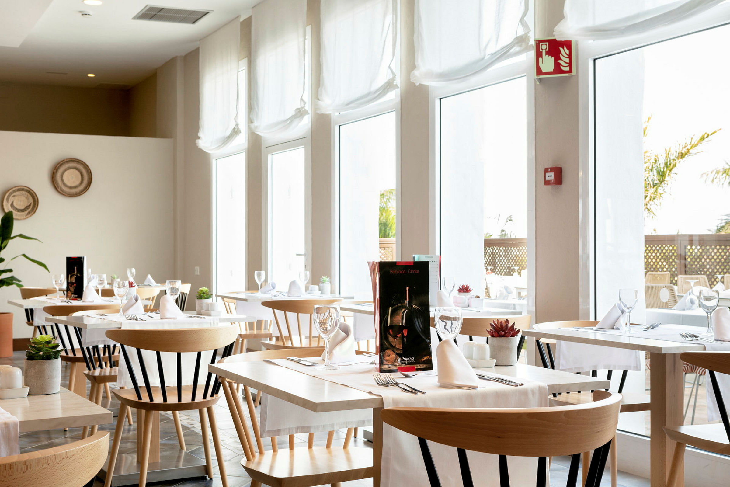 Valoisa ja moderni ravintola, jossa on pöytiä ja tuoleja, sisustettu valkoisilla pöytäliinoilla ja laseilla. (Tekoälyn luoma teksti)