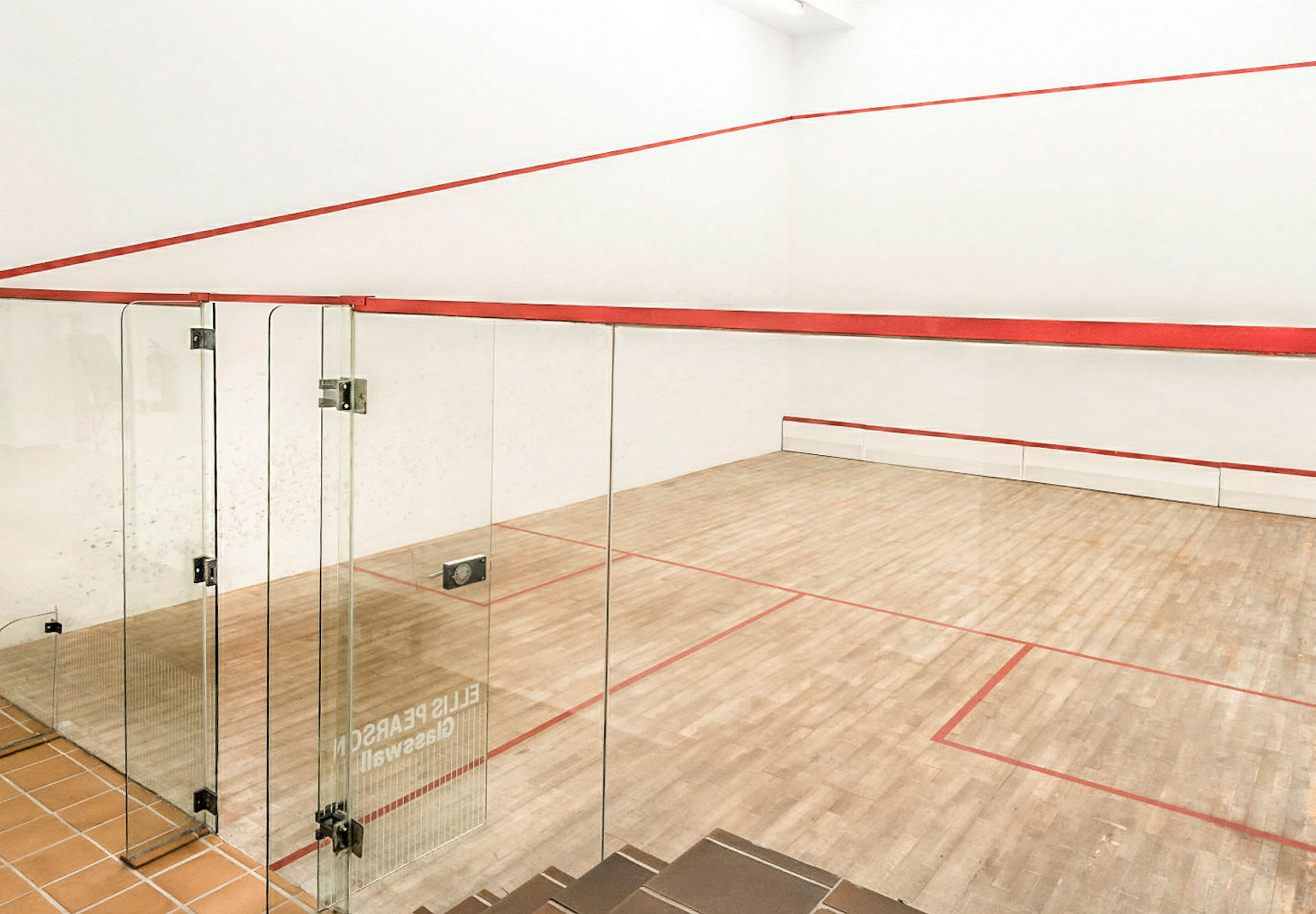 Squashkenttä, jossa on puulattia ja lasiseinät. (Tekoälyn luoma teksti)