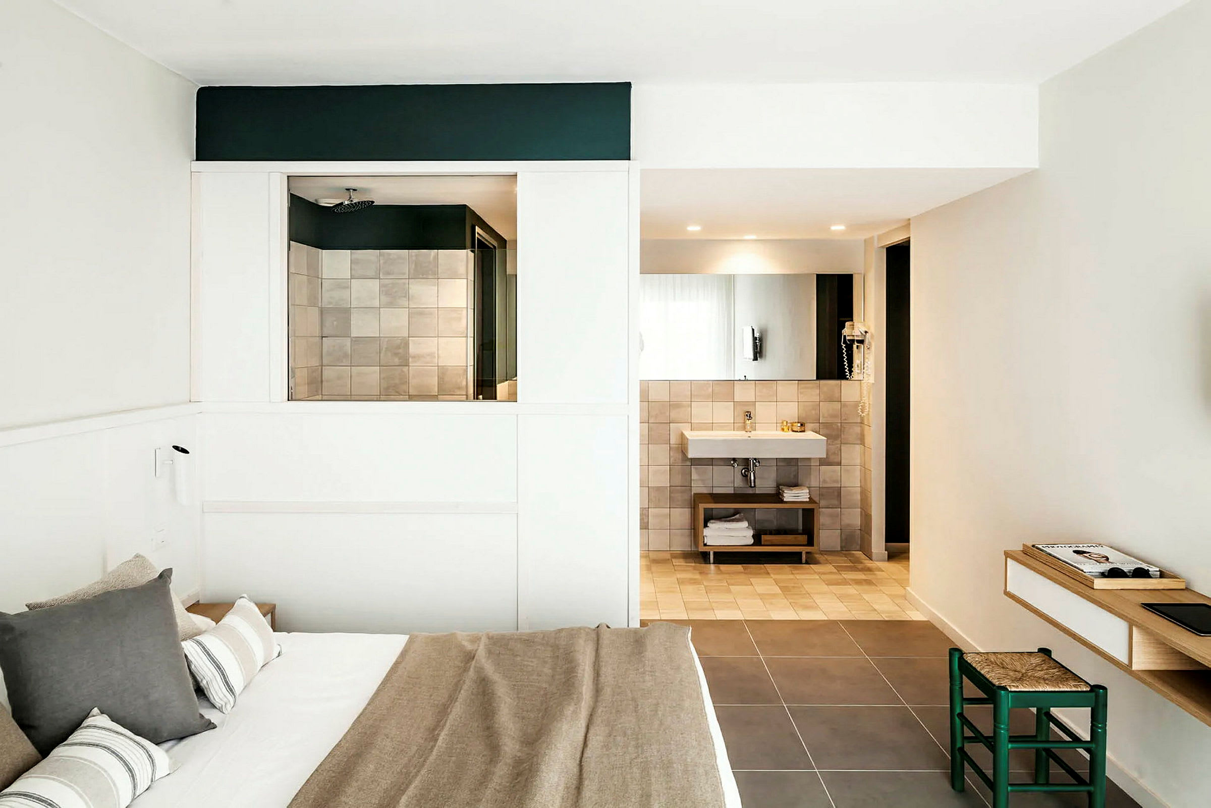 Moderni hotellihuone, jossa on parivuode, kylpyhuone, jossa peili ja pesuallas, sekä pieni työtila tuoleineen. (Tekoälyn luoma teksti)