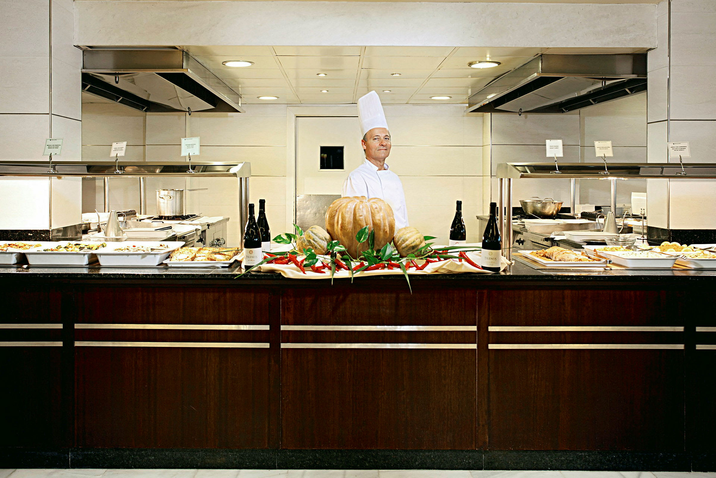 Buffet jossa erilaisia ruokalajeja lounaaksi tai päivälliseksi, keskellä kurpitsa- ja chilikoristeita. (Tekoälyn luoma teksti)