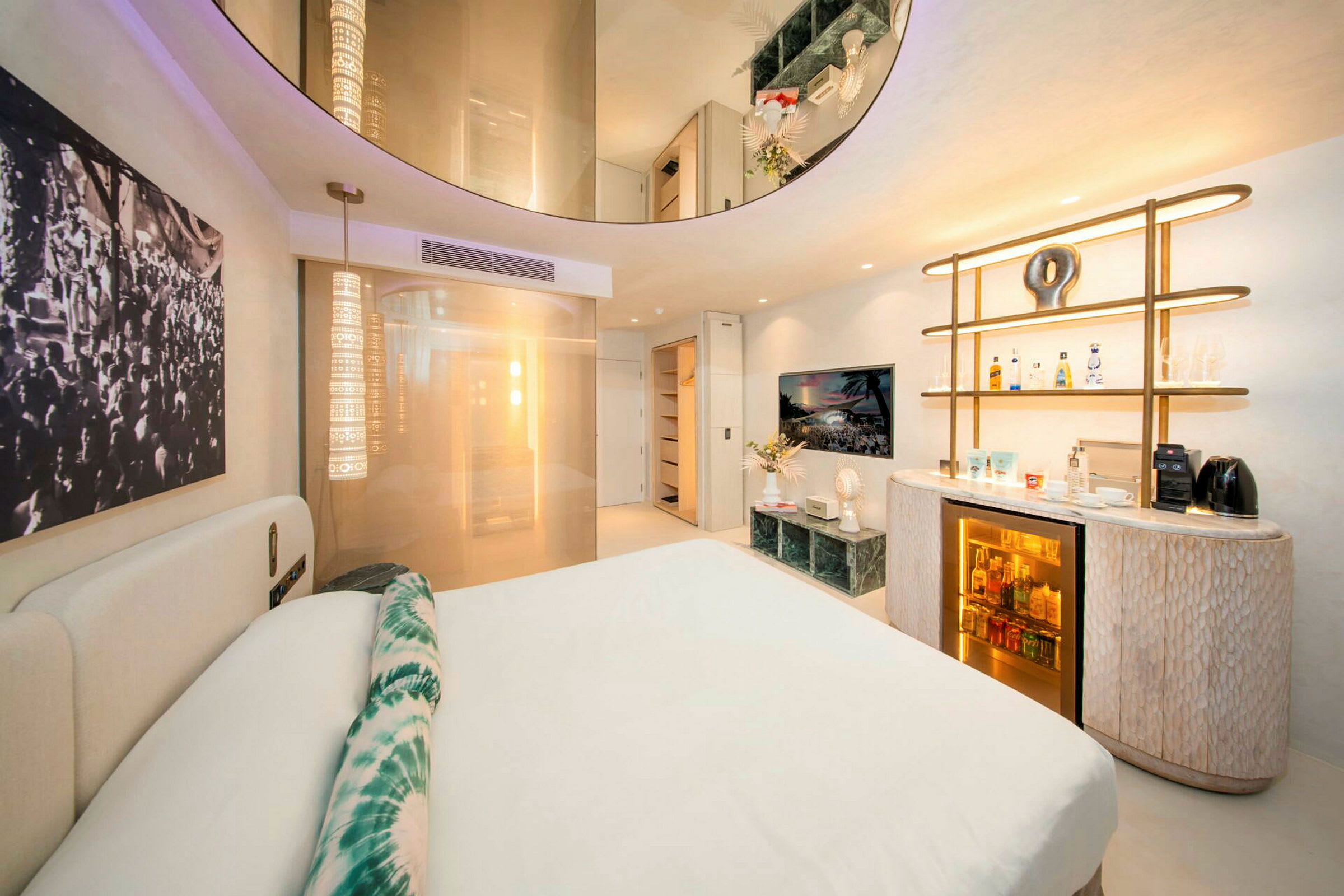 Moderni hotellihuone, jossa on parivuode, koristeelliset valot ja minibaari. (Tekoälyn luoma teksti)