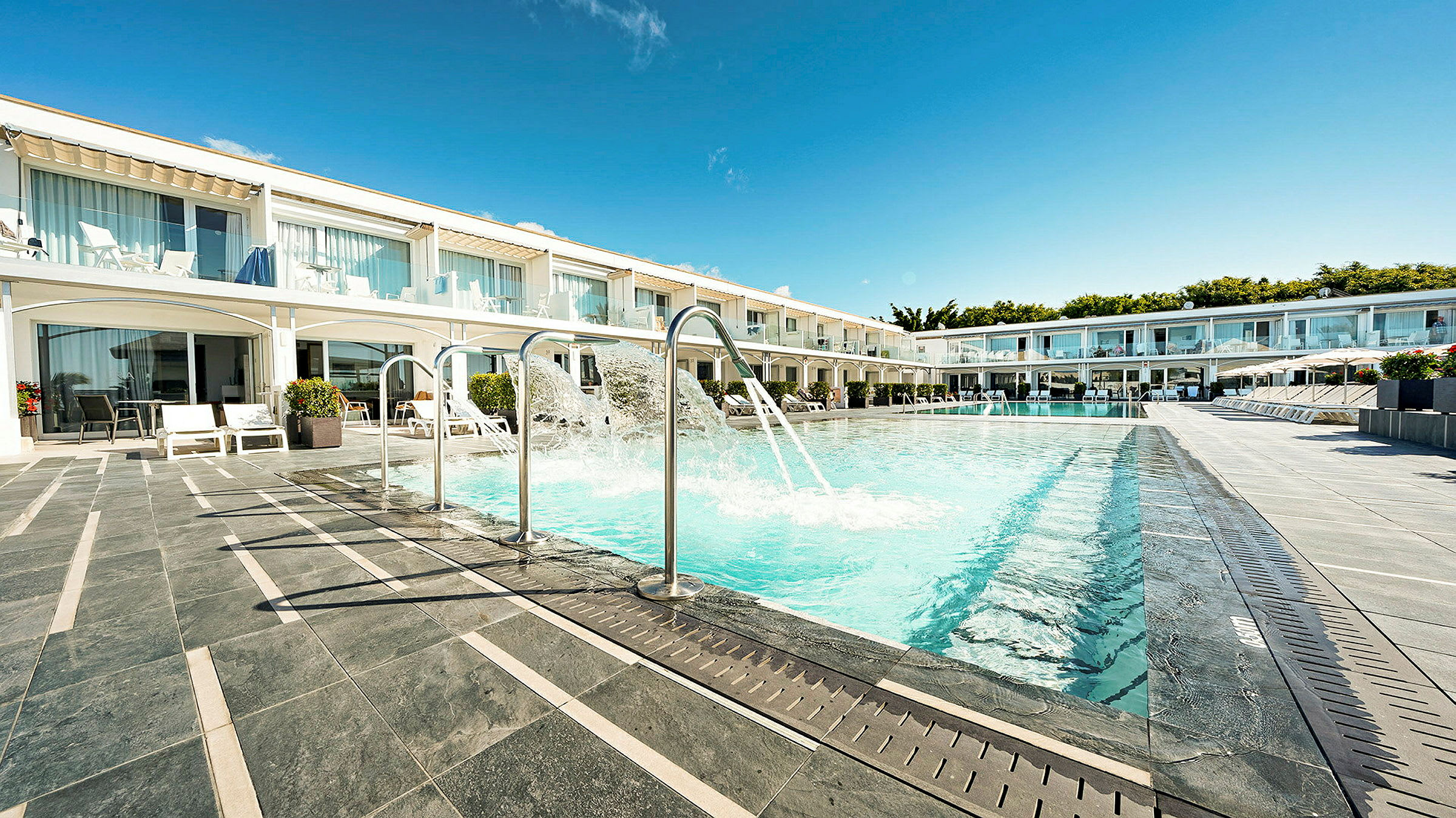 Ulkouima-allas roiskeominaisuuksineen hotellihuoneiden rivistöjen edessä. (Tekoälyn luoma teksti)