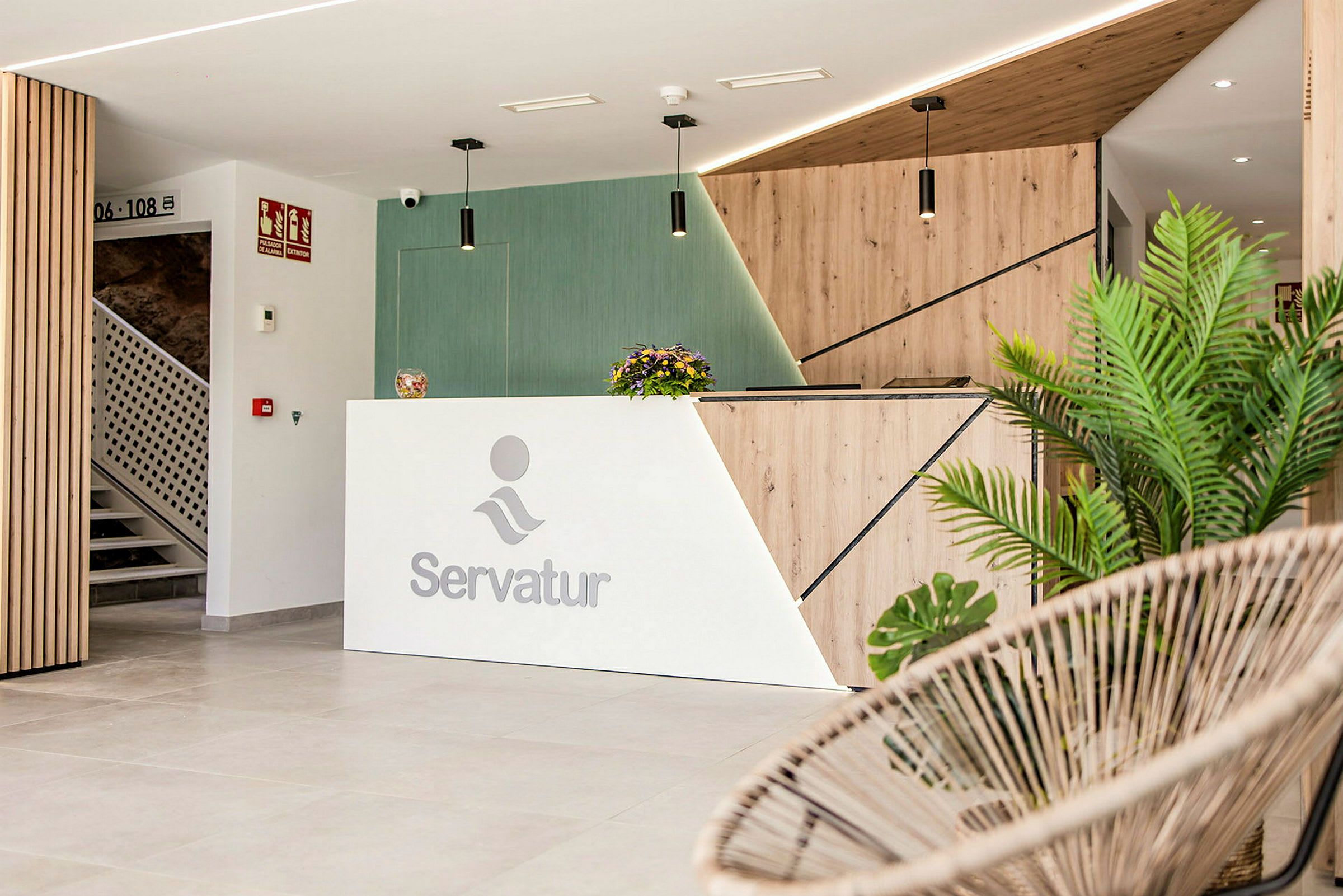 Servatur-logolla varustettu vastaanotto, moderni muotoilu ja koristekasvit. (Tekoälyn luoma teksti)