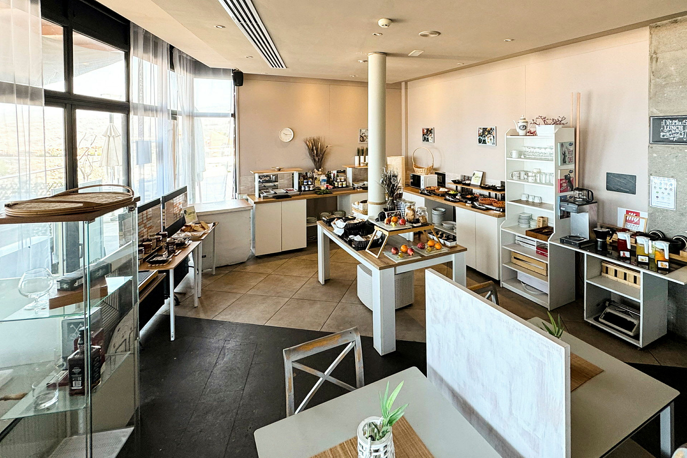 Buffet, jossa on erilaisia ruokia ja juomia, järjestetty valoisaan ja moderniin tilaan. (Tekoälyn luoma teksti)