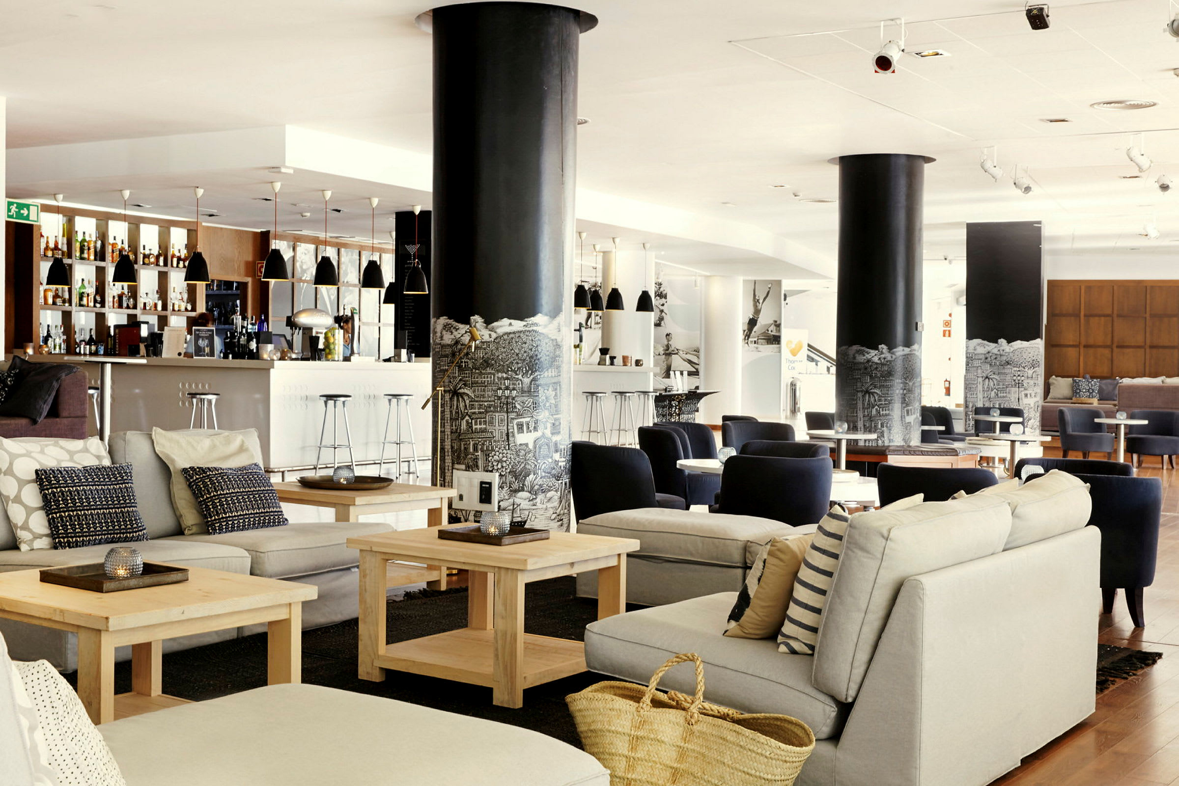 Valoisa ja moderni lounge-alue istuinryhmillä ja baarilla. (Tekoälyn luoma teksti)