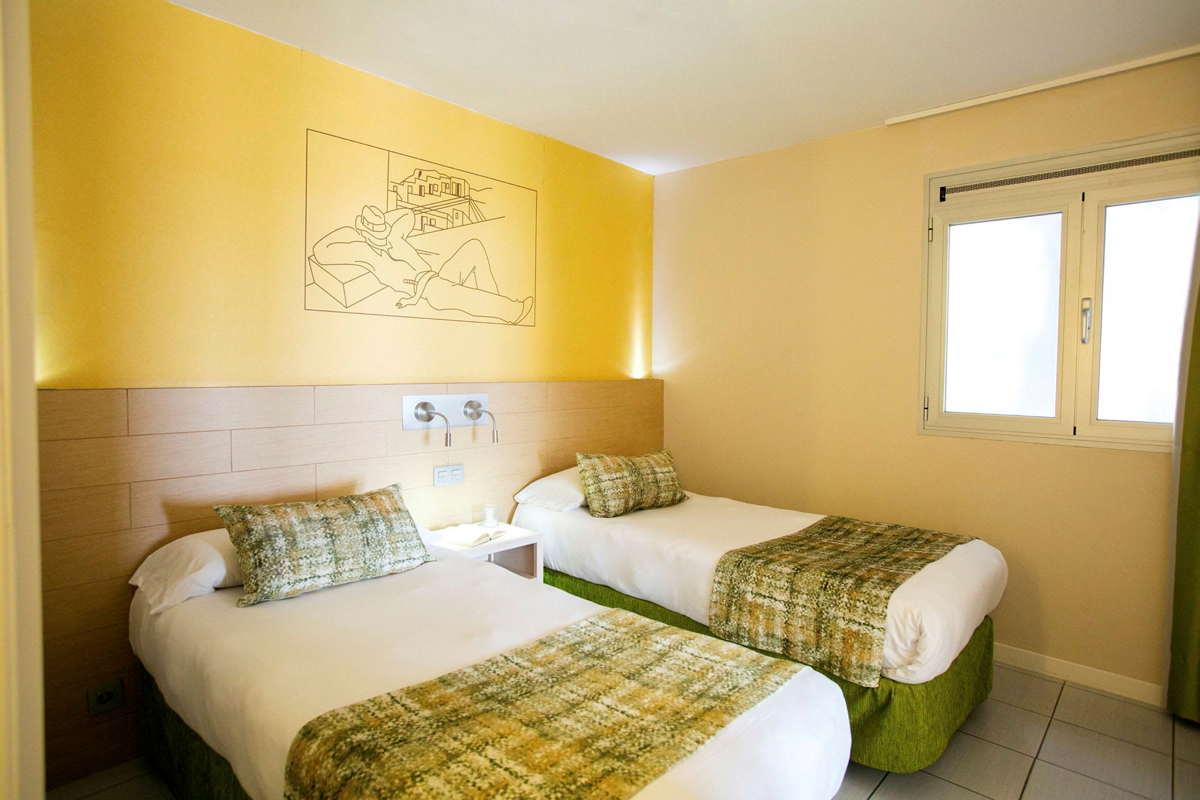 Hotellihuone, jossa kaksi yhden hengen sänkyä, vaaleankeltainen seinä ja ikkuna. (Tekoälyn luoma teksti)