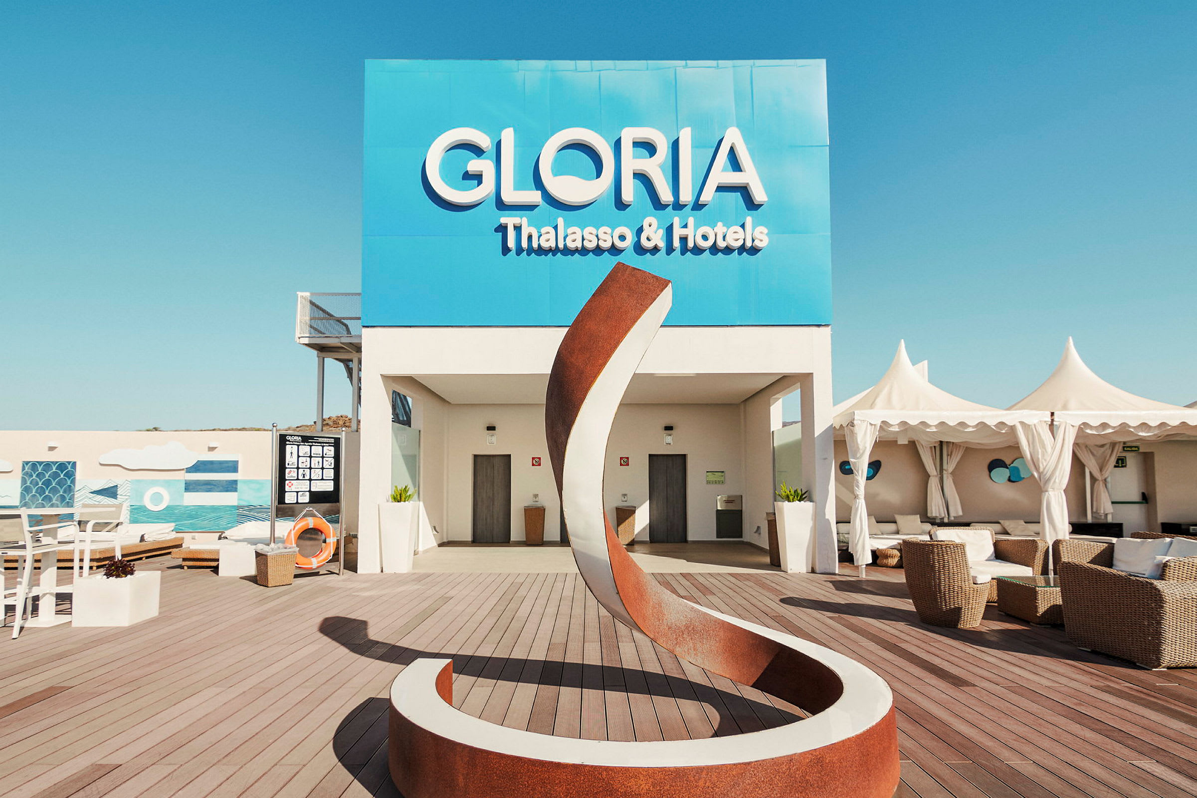 Gloria Thalasso & Hotelin ulkoalue, jossa moderni veistos ja istumapaikkoja. (Tekoälyn luoma teksti)