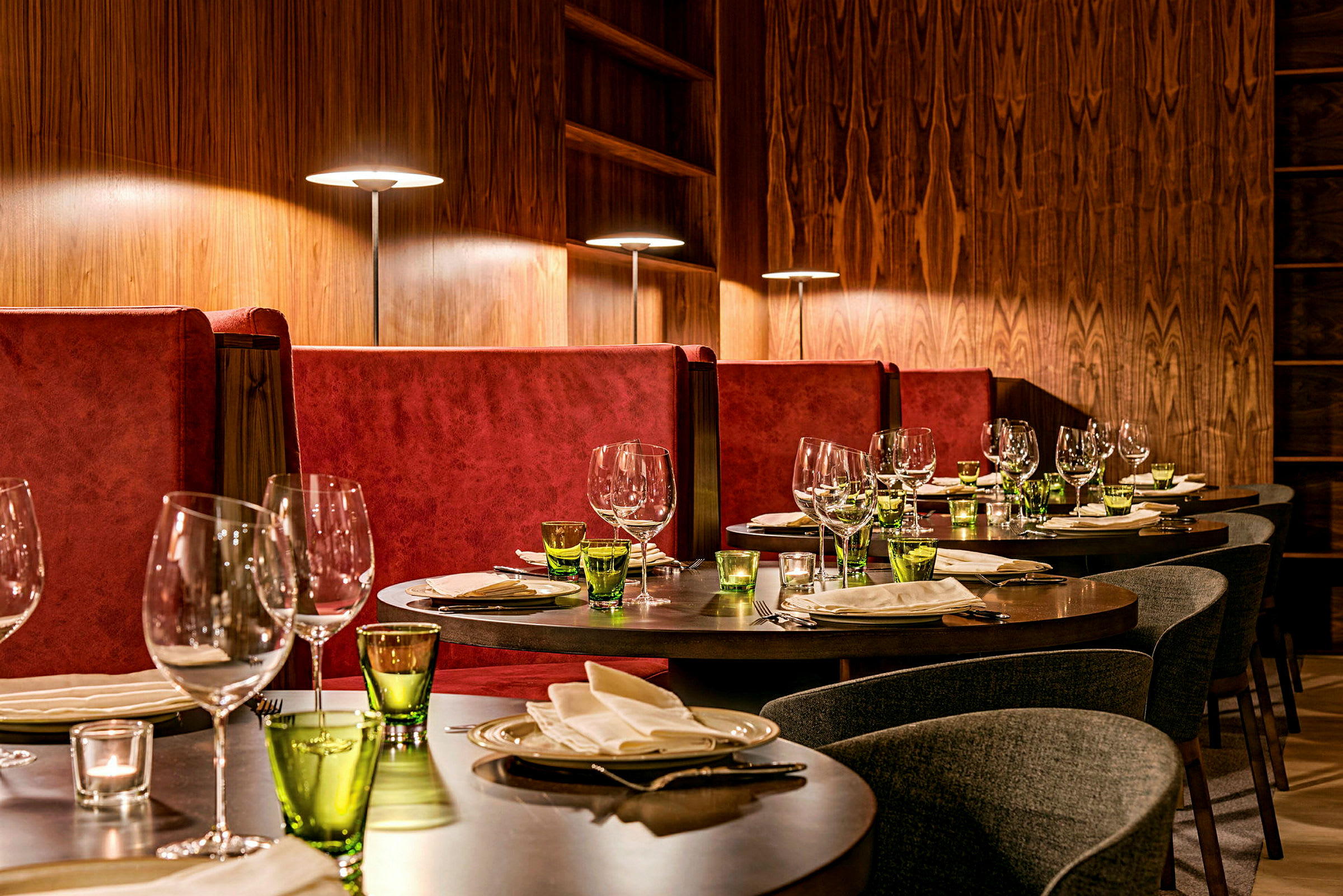 Tyylikäs ravintola, jossa katetut pöydät ja punaiset sohvat. (Tekoälyn luoma teksti)