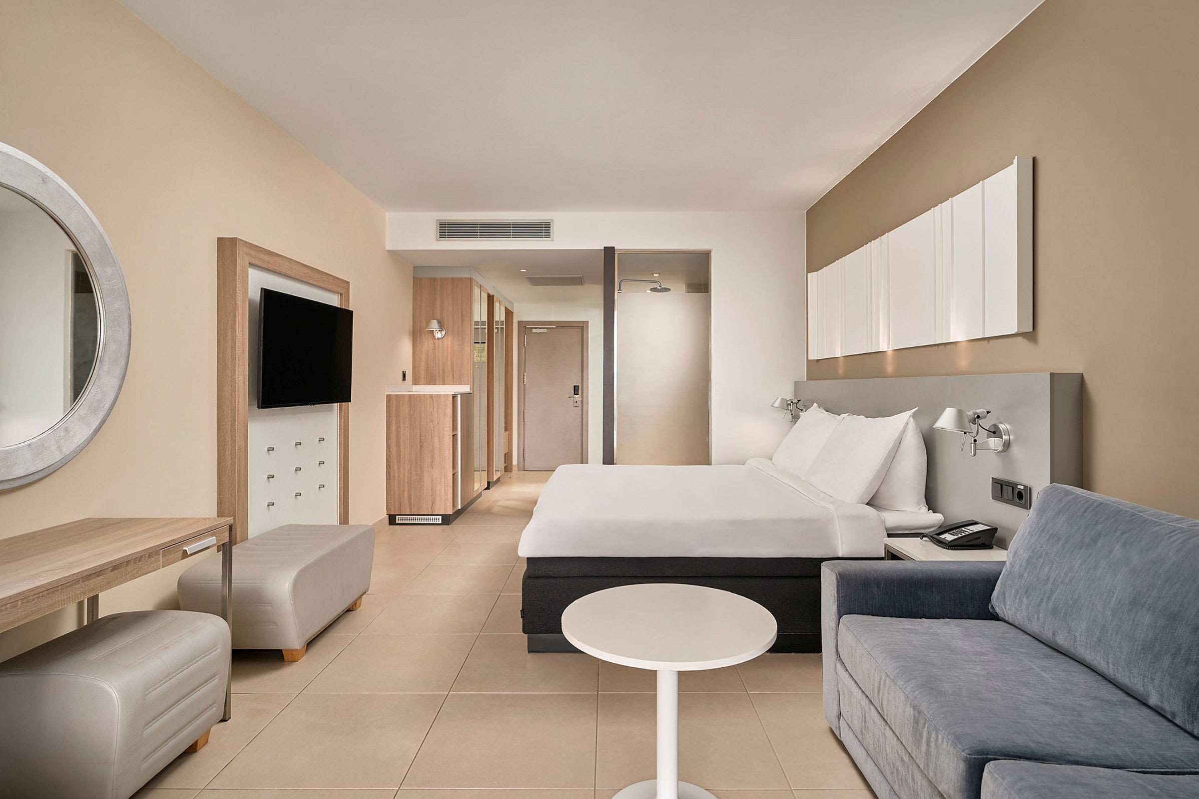 Hotellihuone, jossa parivuode, sohva ja kirjoituspöytä. (Tekoälyn luoma teksti)