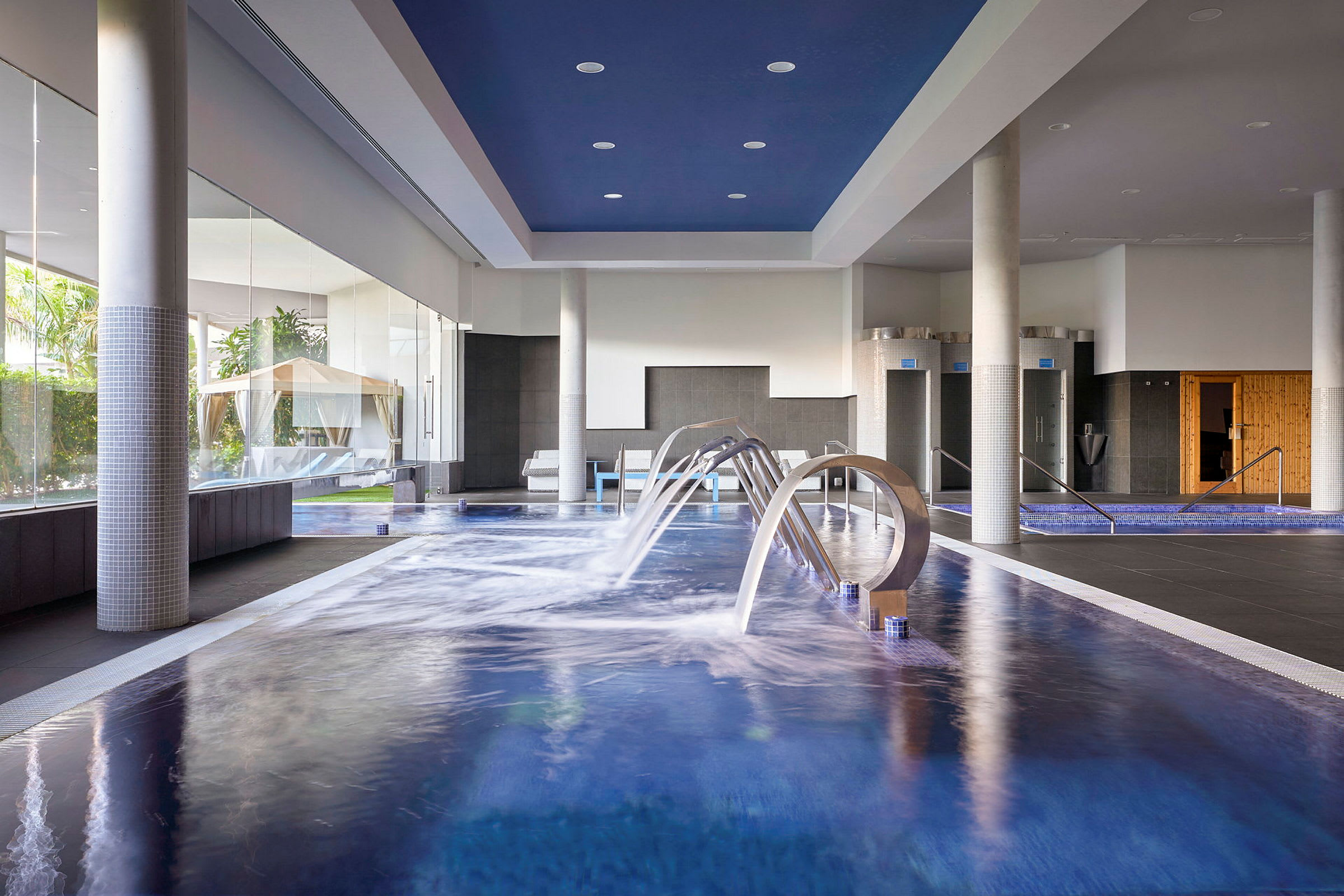 Sisäuima-allas vesielementeillä ja ympäröivä spa-alue. (Tekoälyn luoma teksti)