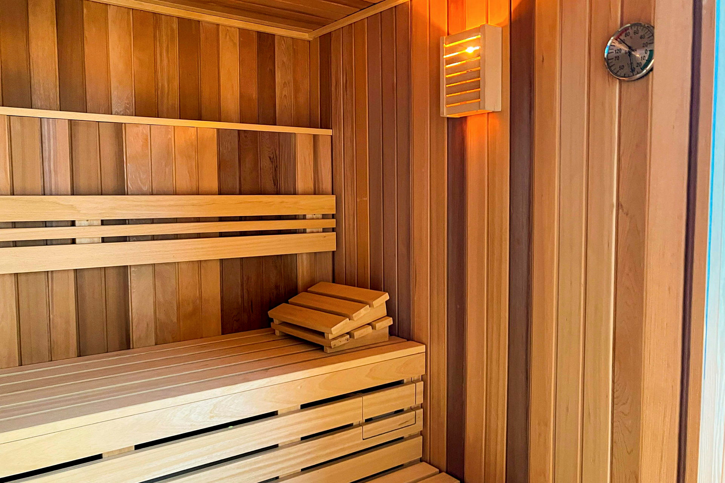 Puisesti sisustettu sauna, jossa penkki ja lämpömittari. (Tekoälyn luoma teksti)