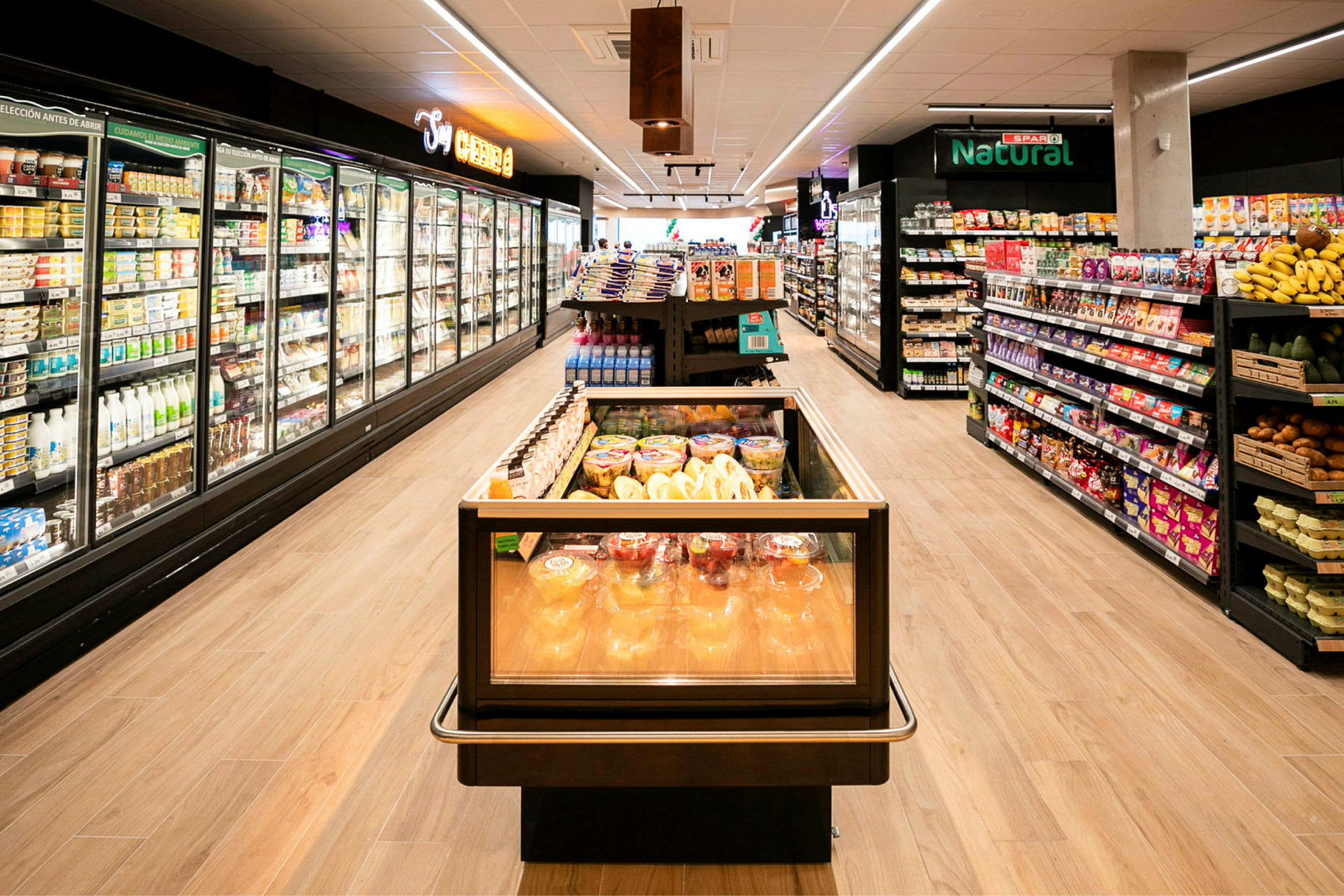 Moderni supermarketti, jossa hyllyillä on tavaroita ja seinillä kylmäkaappeja. (Tekoälyn luoma teksti)