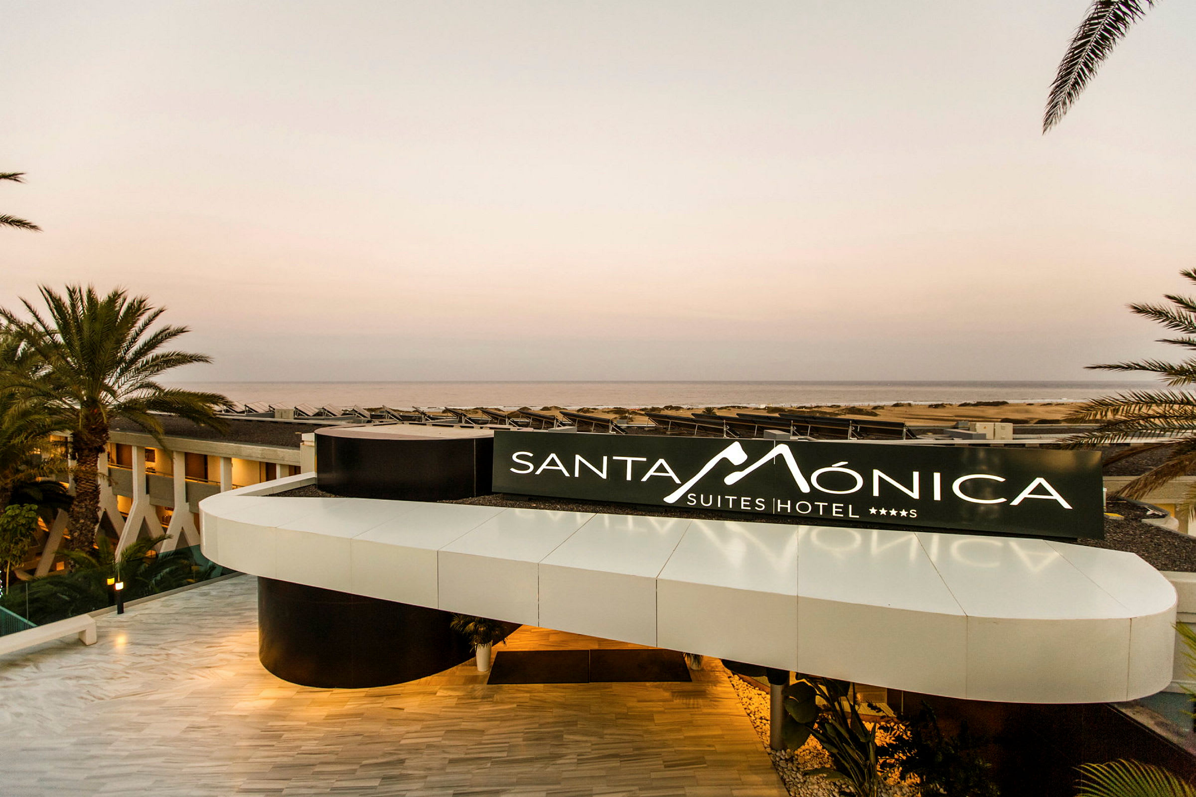 Sisäänkäynti, jossa Santa Monica Suites Hotel -kyltti. (Tekoälyn luoma teksti)