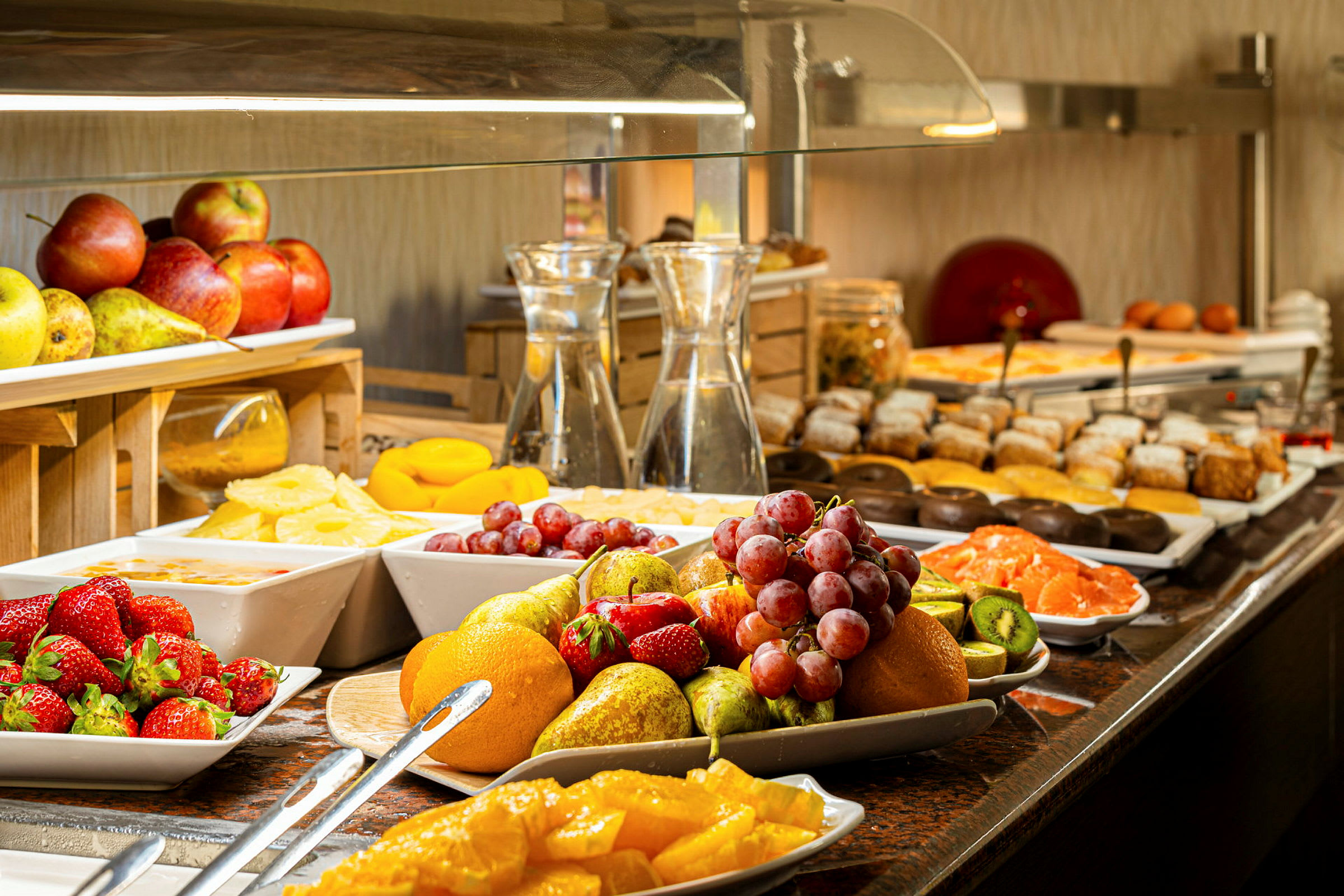 Buffet, jossa erilaisia tuoreita hedelmiä ja leivonnaisia. (Tekoälyn luoma teksti)