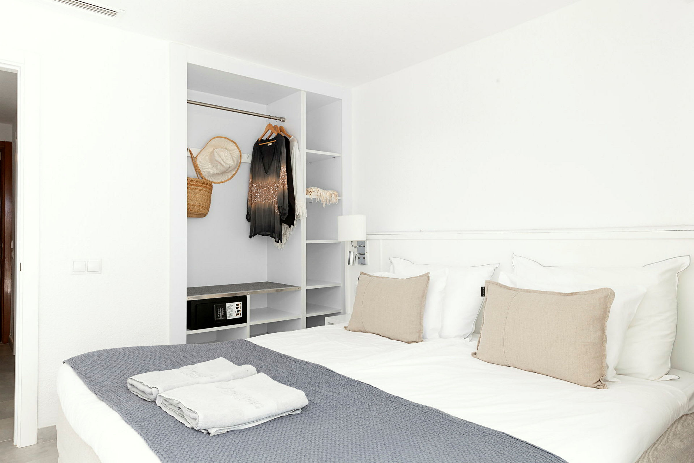 Hotellihuone, jossa parivuode ja avoin vaatekaappi. (Tekoälyn luoma teksti)