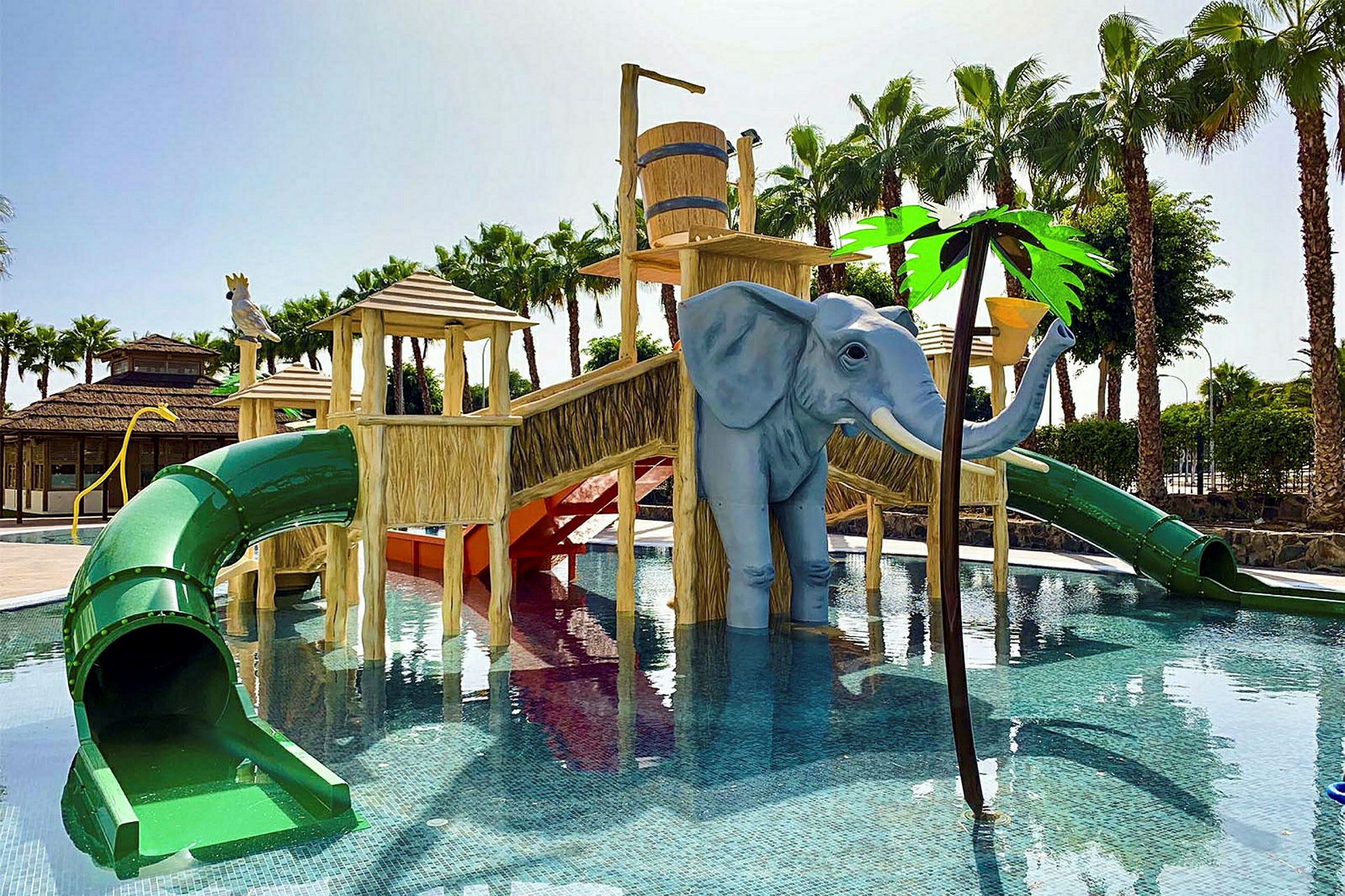 Kuva lasten altaasta, jossa on elefantin muotoisia vesileluja ja vesiliukumäkiä. (Tekoälyn luoma teksti)