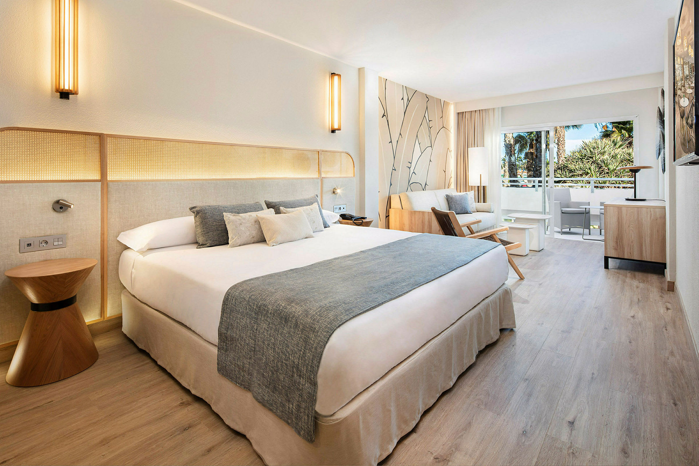 Hotellihuone, jossa parivuode, oleskelutila ja parveke näkymällä. (Tekoälyn luoma teksti)