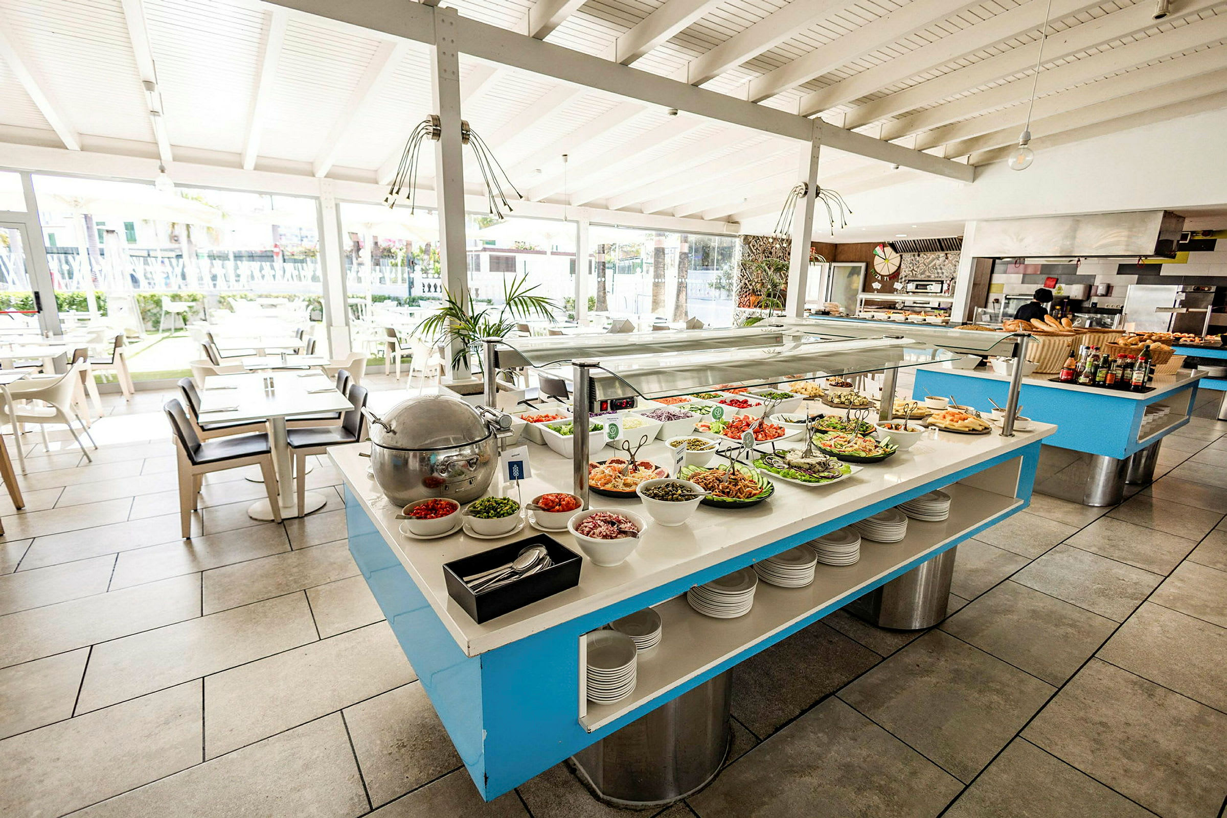 Buffet, jossa on salaatteja ja erilaisia ruokia valoisassa ruokasalissa. (Tekoälyn luoma teksti)