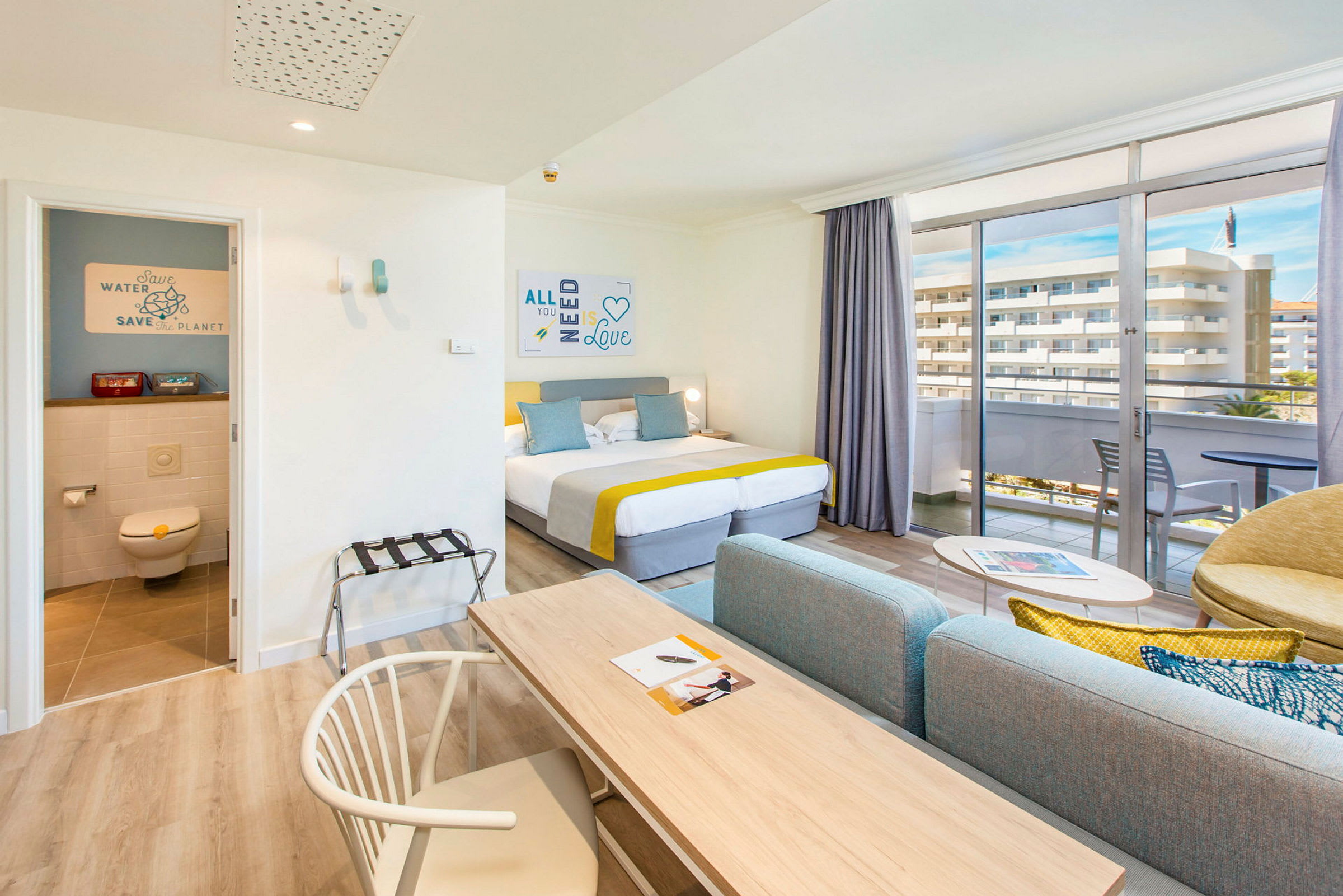Hotellihuone, jossa on parivuode, oleskeluryhmä ja parveke näköalalla. (Tekoälyn luoma teksti)