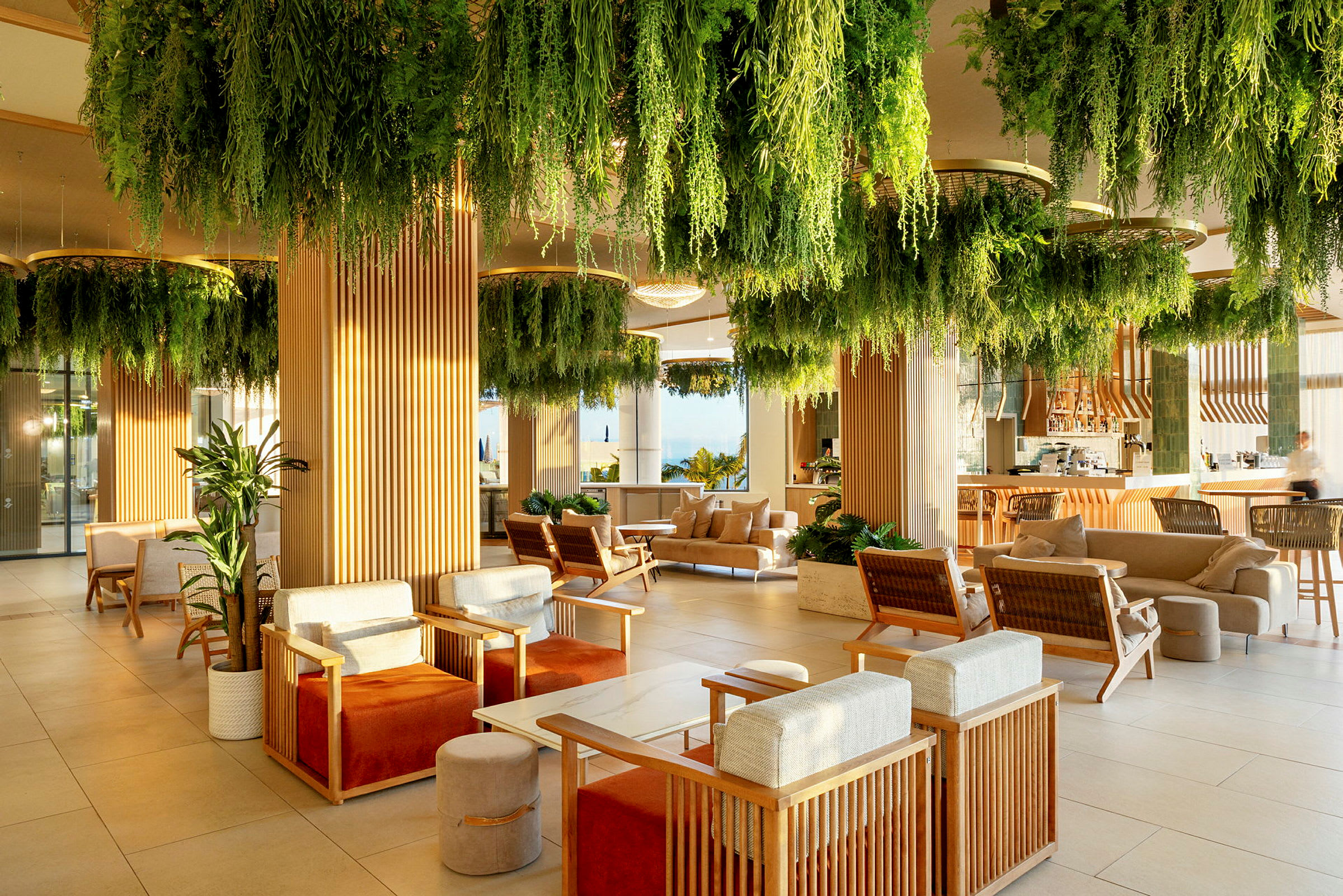 Moderni lounge, jossa istuinryhmiä ja katosta roikkuvia vihreitä kasveja. (Tekoälyn luoma teksti)
