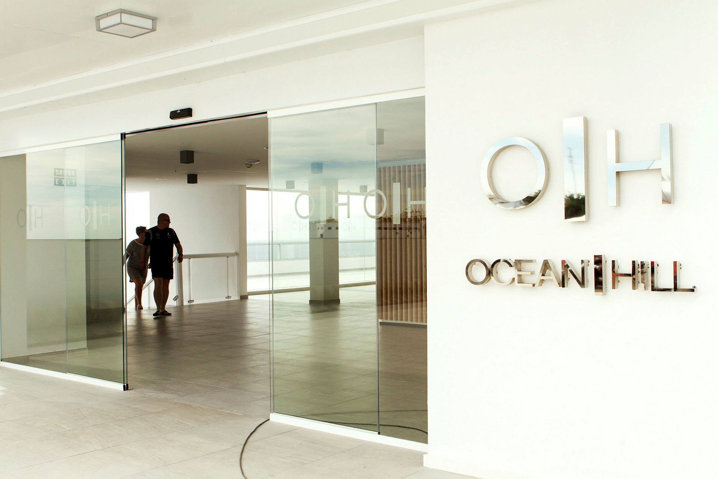 Sisäänkäynti lasiovilla ja kyltillä 'Ocean Hill'. (Tekoälyn luoma teksti)