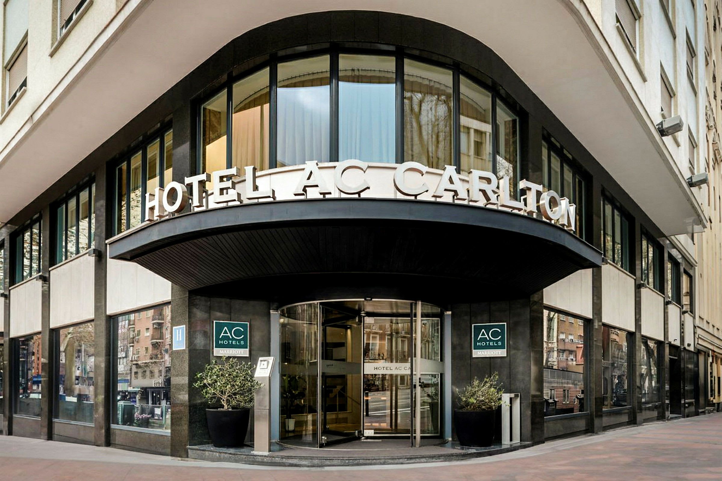 Hotellin julkisivu, jossa on kyltti "HOTEL AC CARLTON" sisäänkäynnin yläpuolella. (Tekoälyn luoma teksti)