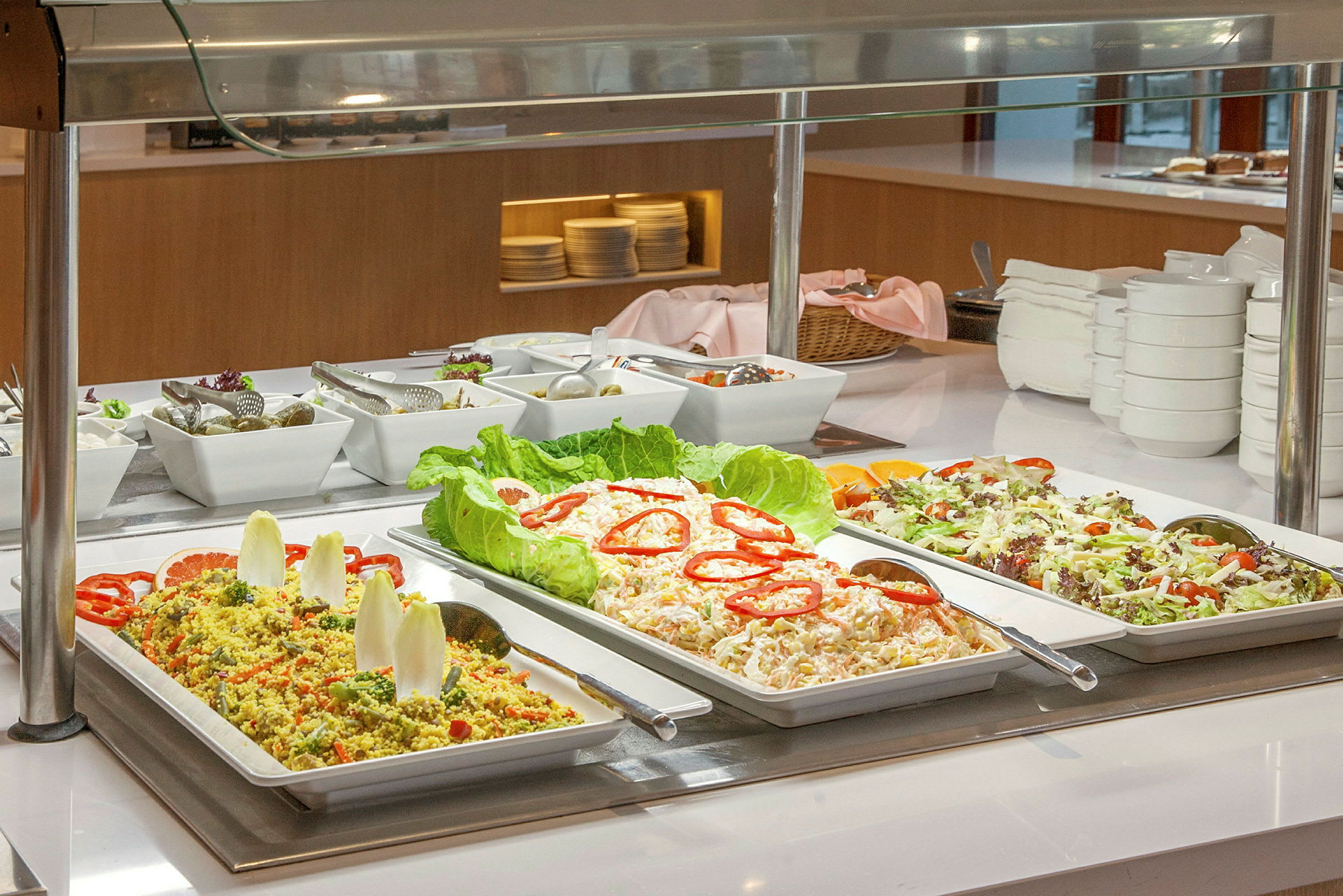 Buffet, jossa salaatteja ja kylmiä ruokia eri tarjoiluastioissa. (Tekoälyn luoma teksti)
