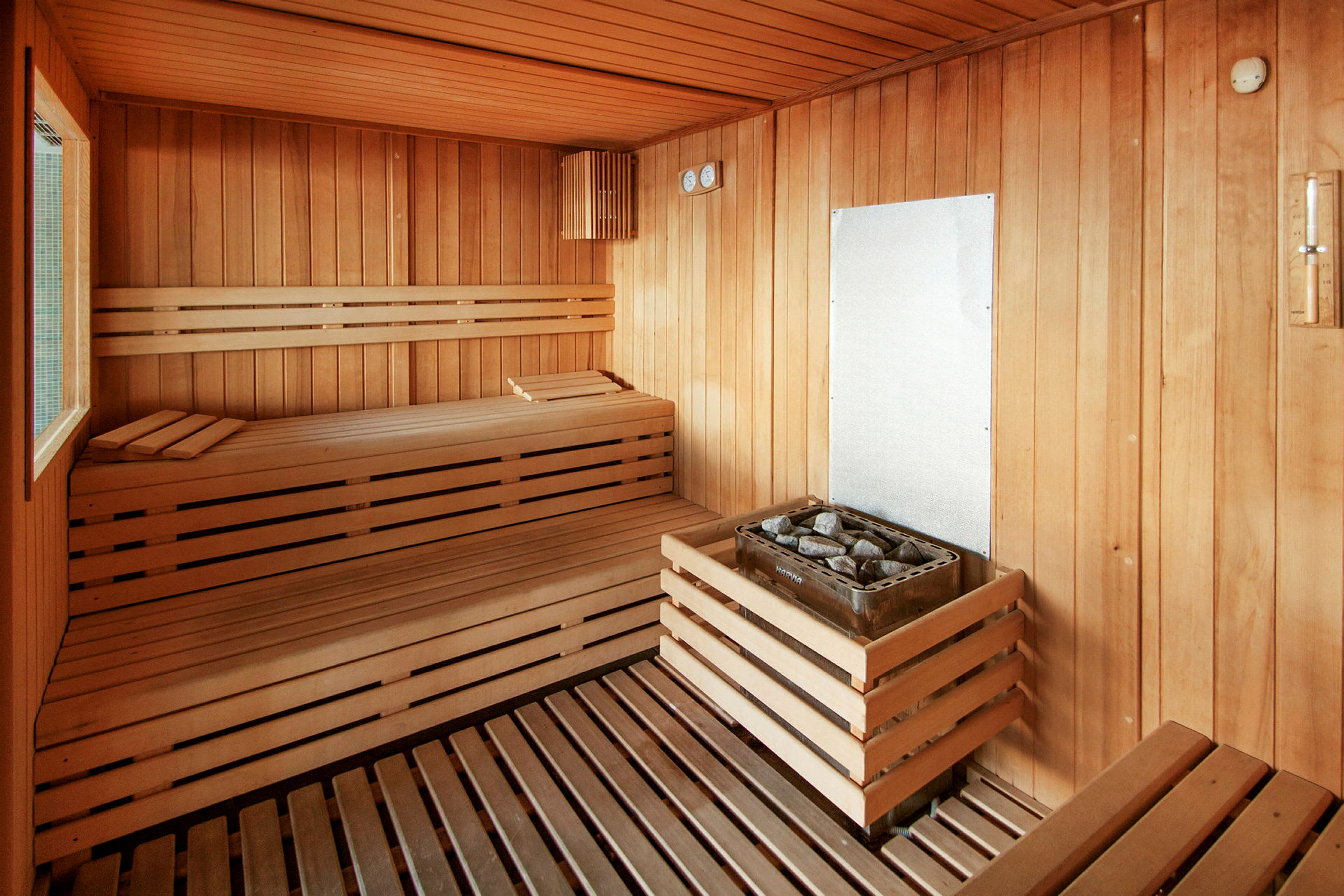 Perinteinen sauna puupaneeleilla, istuimilla ja kiukaalla, jossa kivet. (Tekoälyn luoma teksti)