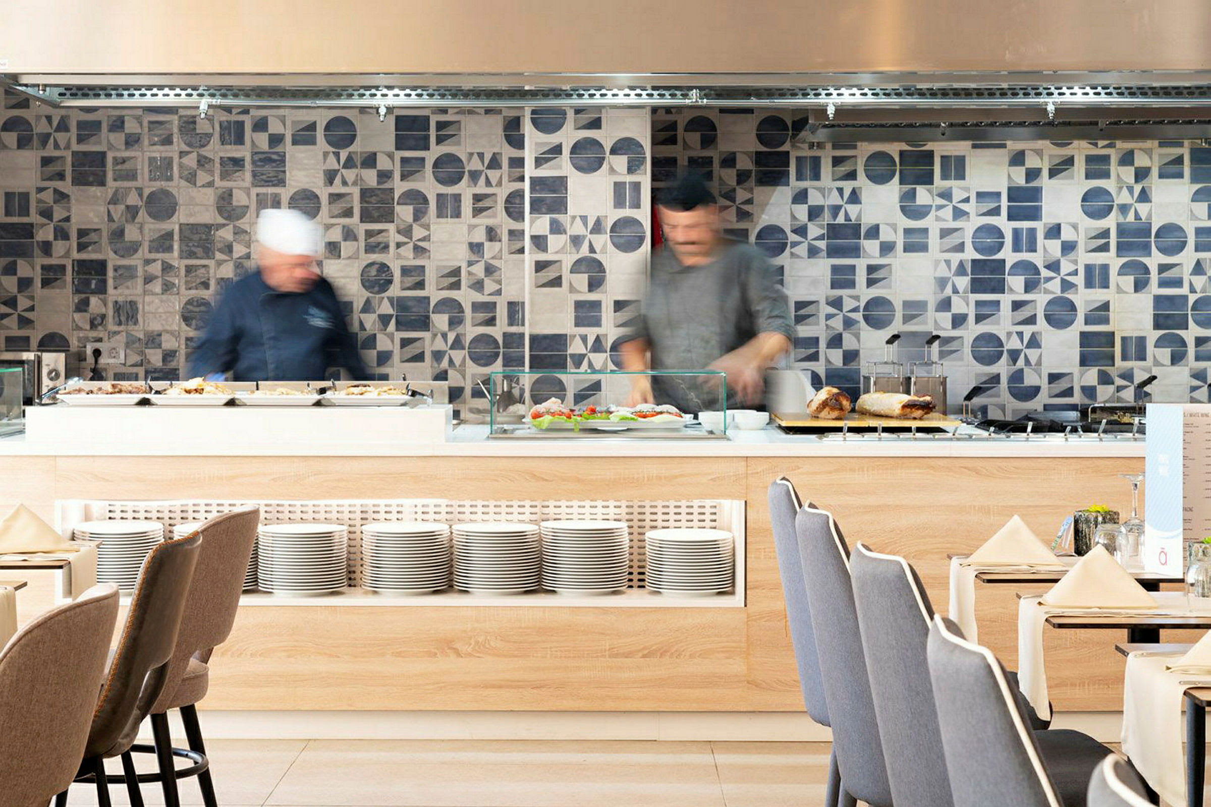 Ravintolan buffet-alue, jossa laattaiset seinät ja lautaset. (Tekoälyn luoma teksti)