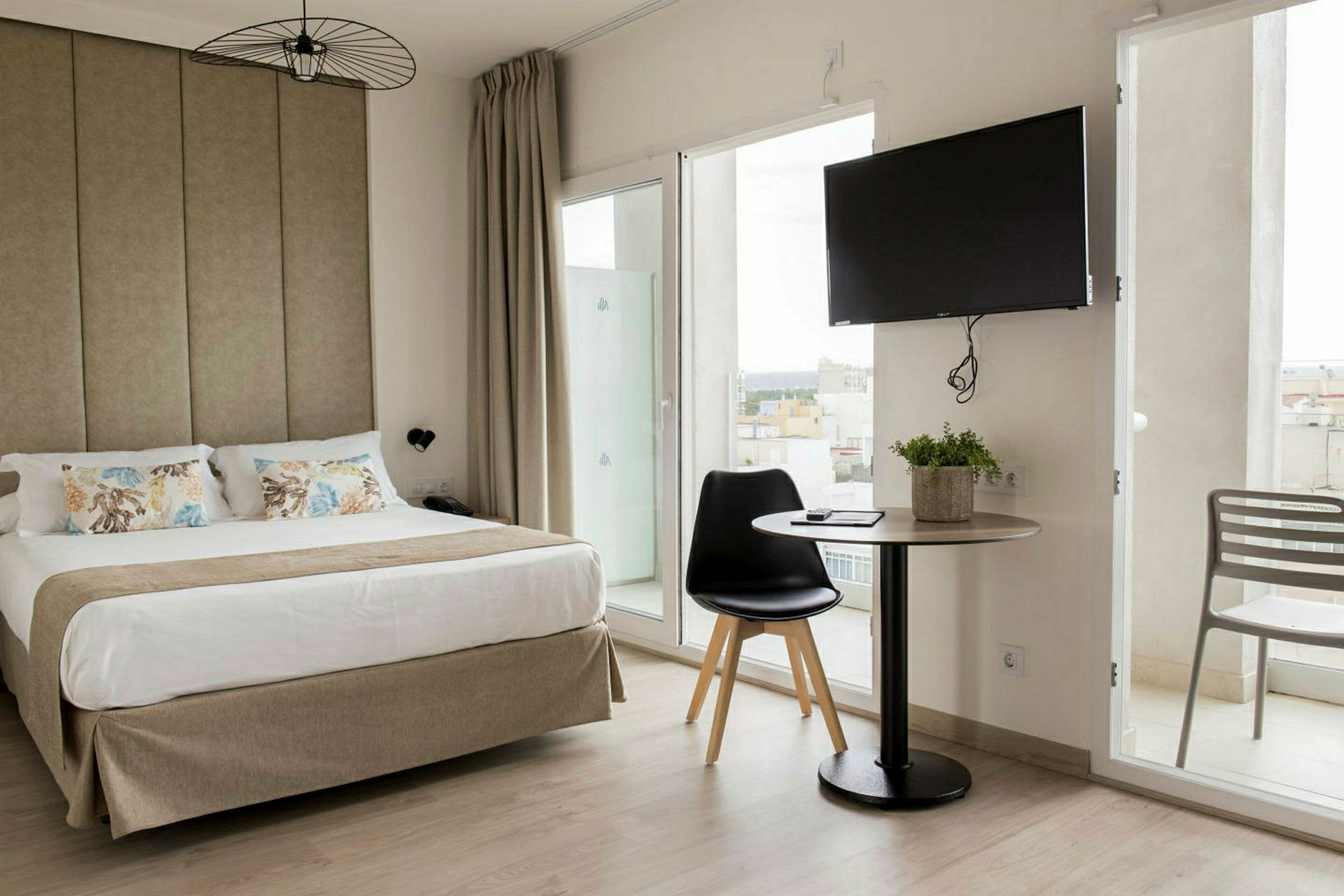Hotellihuone, jossa parivuode, pöytä tuoleineen ja televisio seinällä. (Tekoälyn luoma teksti)
