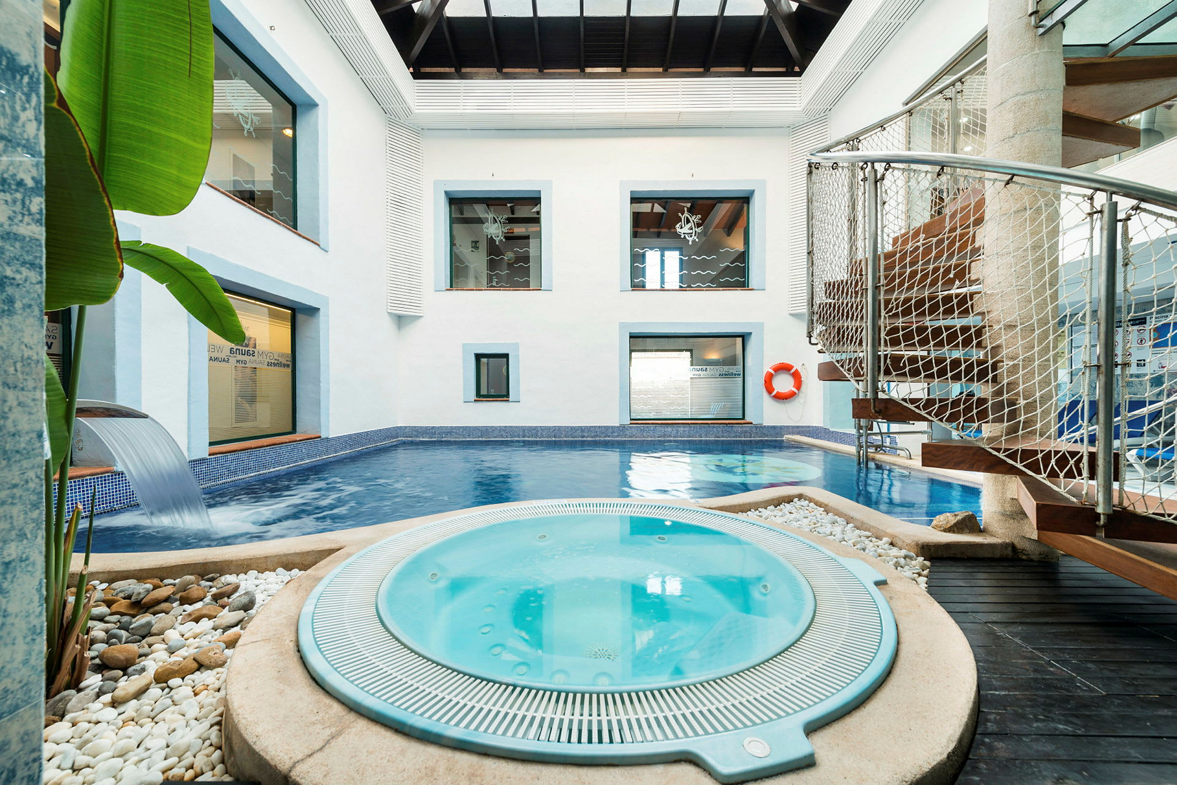 Sisätilan spa, jossa uima-allas ja poreallas, modernien yksityiskohtien ympäröimänä. (Tekoälyn luoma teksti)