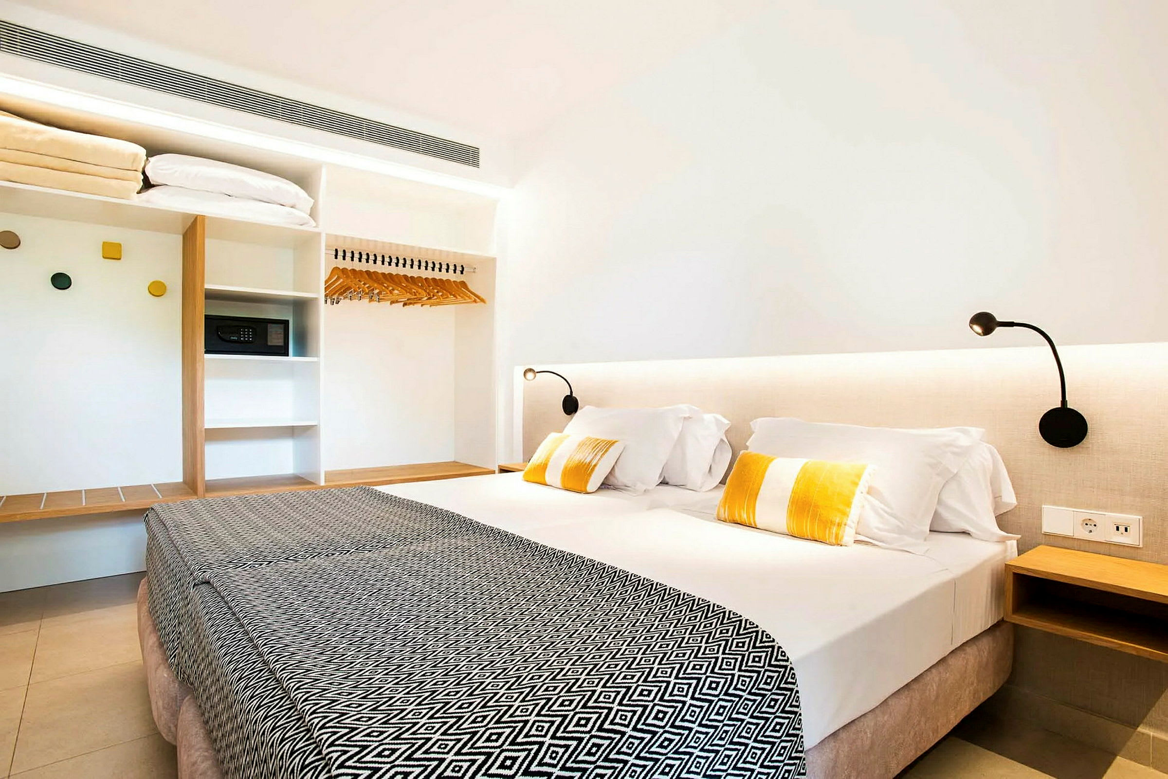 Hotellihuone, jossa on parivuode, lukulamput ja vaatekaappi. (Tekoälyn luoma teksti)