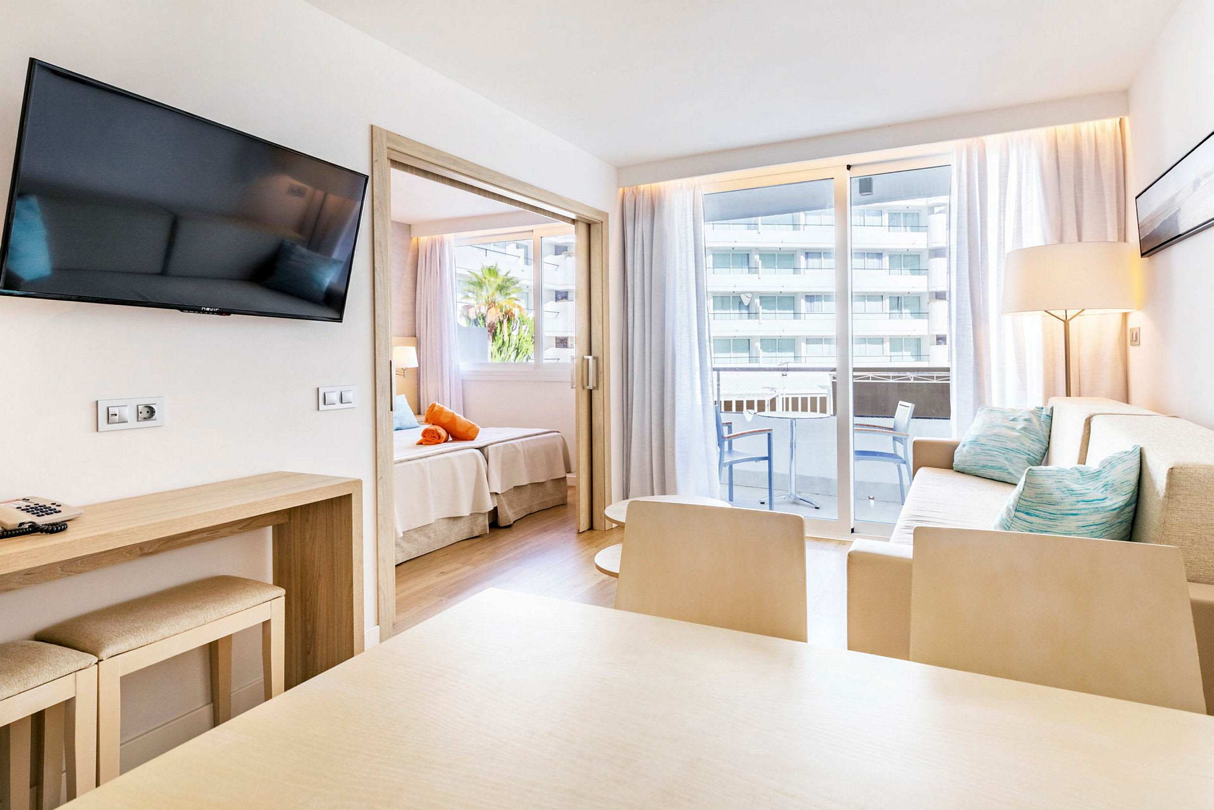 Moderni hotellihuone, jossa oleskelutila, ruokapöytä, parveke ja makuutila. (Tekoälyn luoma teksti)