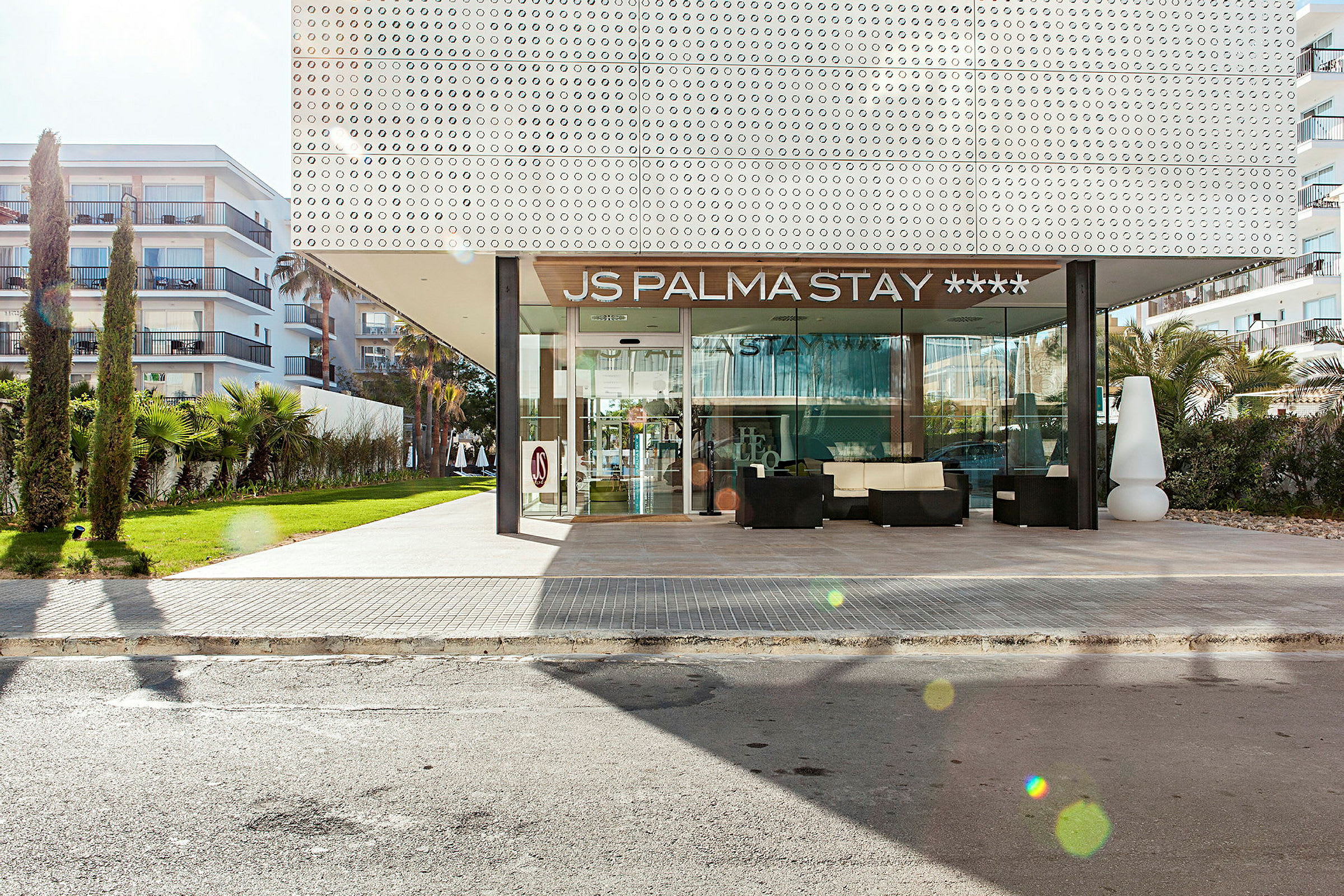 JS Palma Stay -hotellin ulkopuoli sisäänkäynnillä ja ympäröivällä vehreydellä. (Tekoälyn luoma teksti)