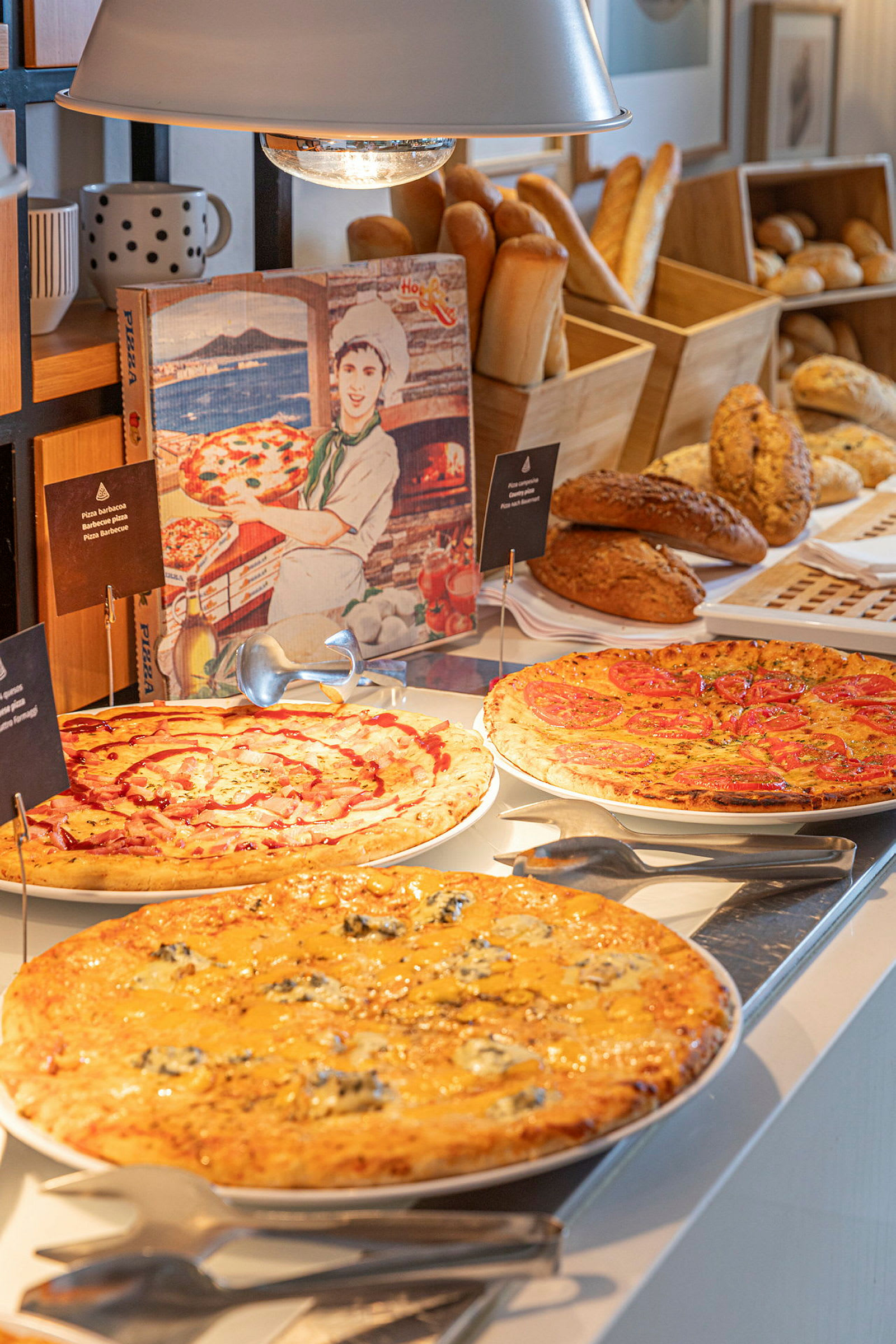 Buffetti, jossa on erilaisia pizzoja ja leipiä. (Tekoälyn luoma teksti)