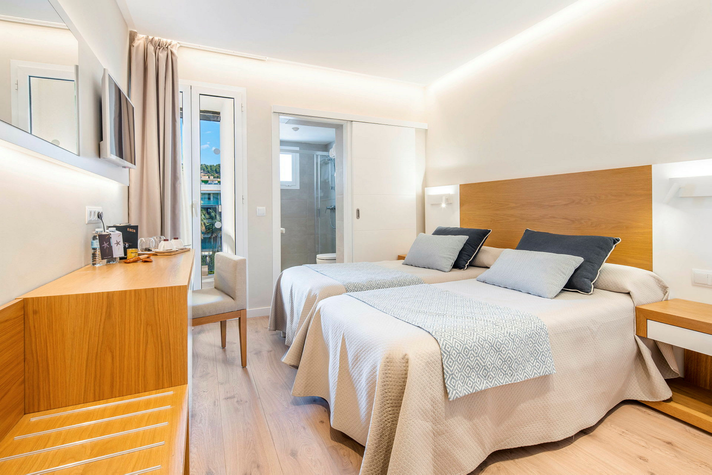 Hotellihuone, jossa on kaksi yhden hengen sänkyä puuyksityiskohdilla, työskentelytila ​​ja erillinen kylpyhuone. (Tekoälyn luoma teksti)