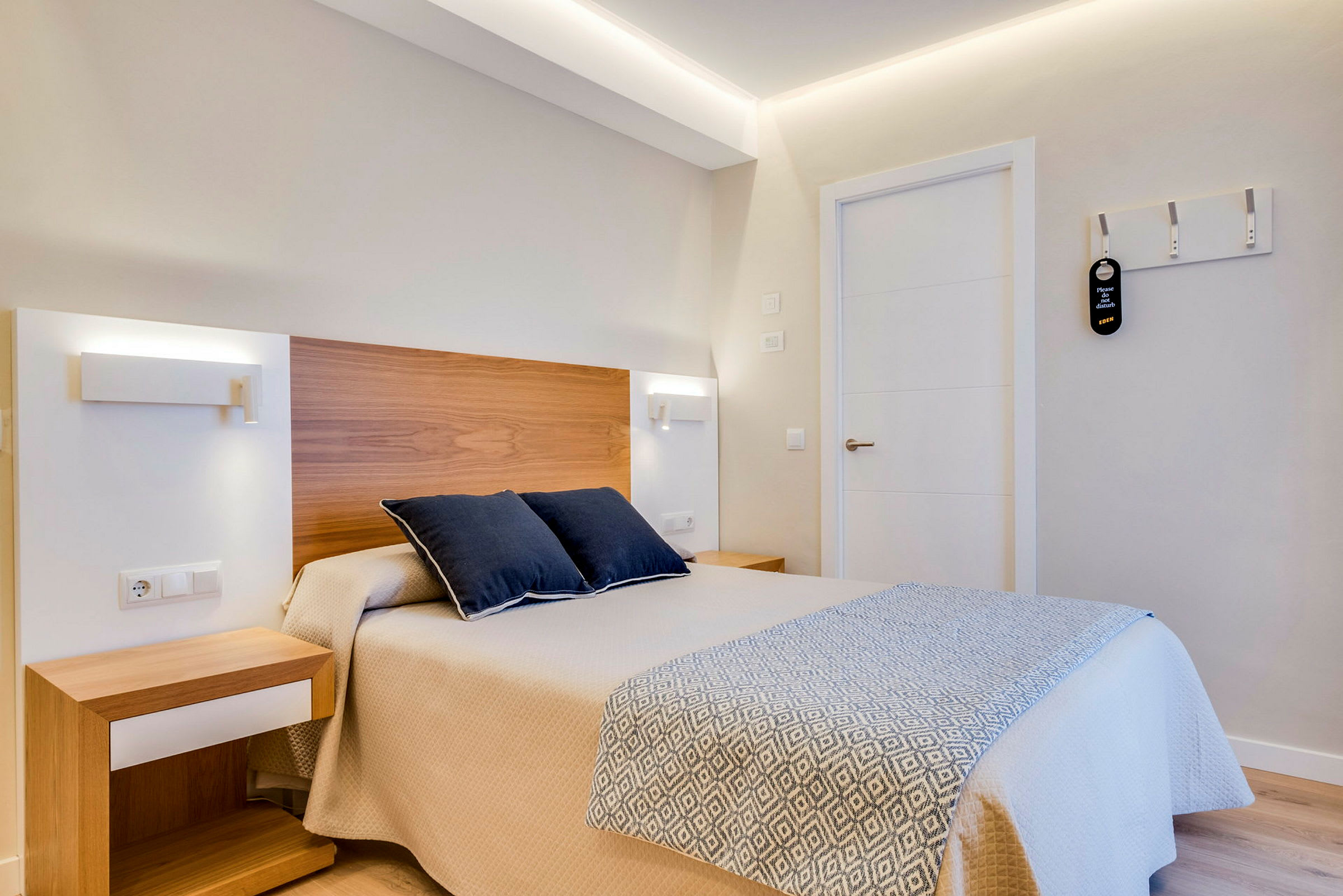 Hotellihuone, jossa on sänky ja kaksi tyynyä. (Tekoälyn luoma teksti)