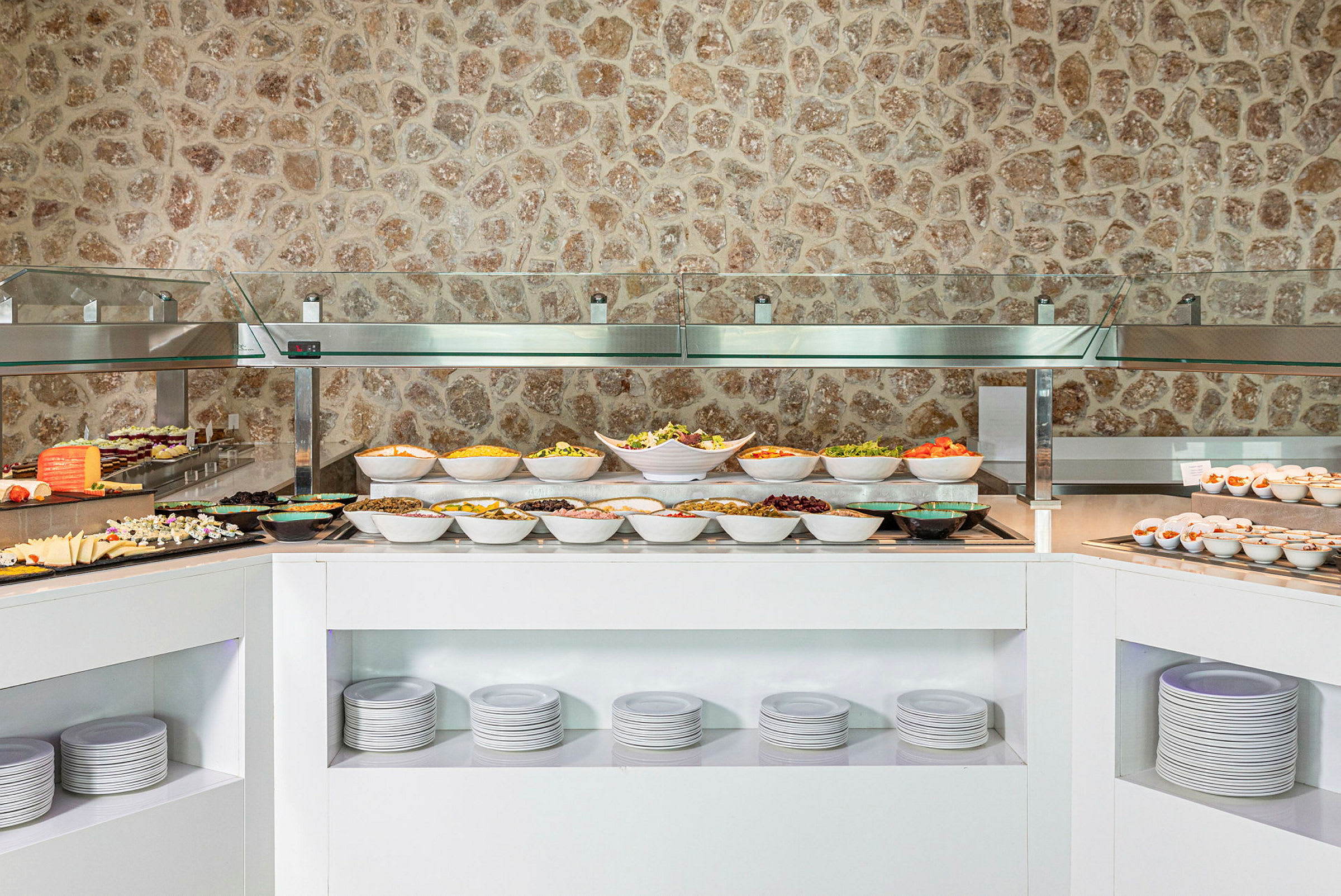 Buffet, jossa erilaisia ruokalajeja ja kulhoja ruokaa. (Tekoälyn luoma teksti)