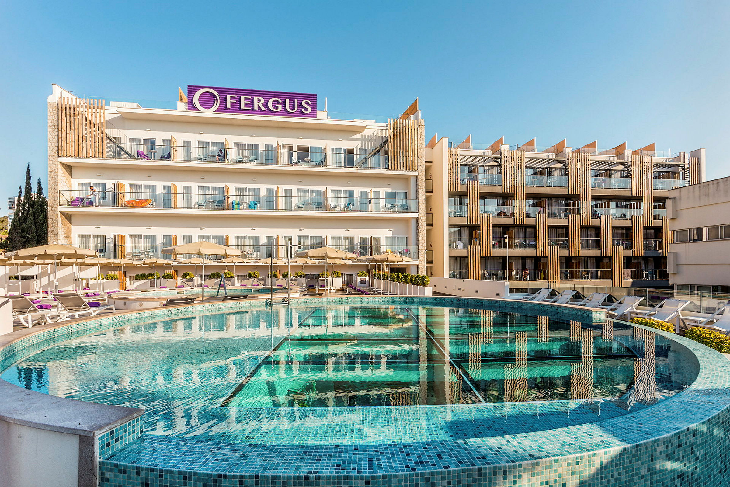 Hotellirakennus, etualalla uima-allas ja aurinkotuoleja. (Tekoälyn luoma teksti)
