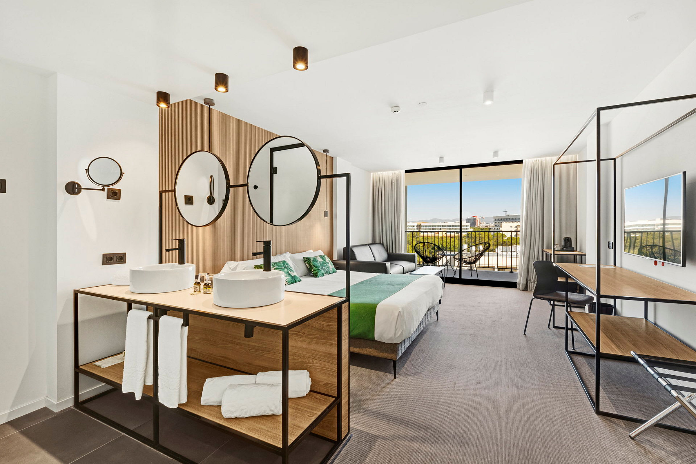 Moderni hotellihuone, jossa on parivuode, istuimet ja kylpyhuoneen osa. (Tekoälyn luoma teksti)