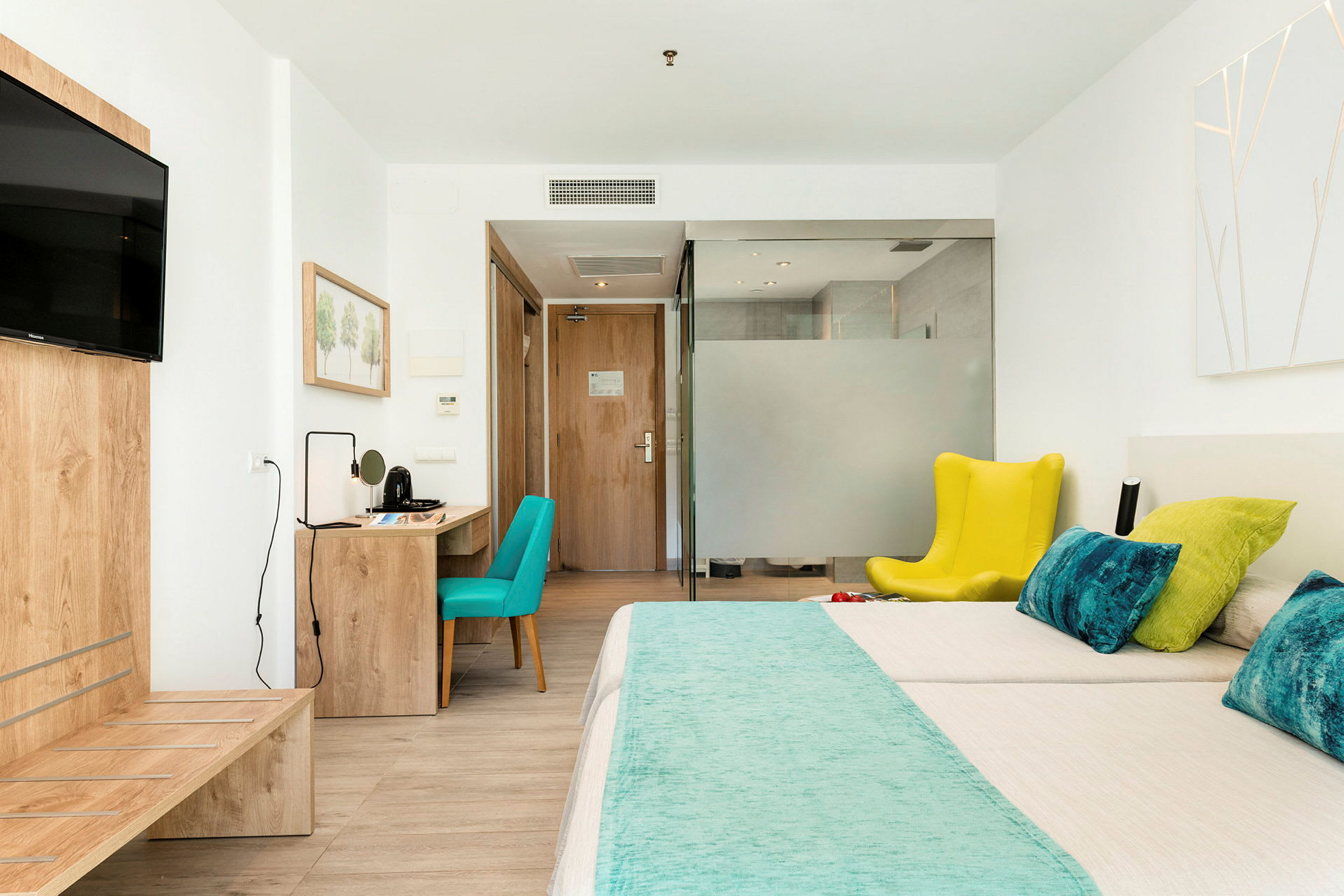 Hotellihuone, jossa on sänky, kirjoituspöytä ja istumapaikka. (Tekoälyn luoma teksti)