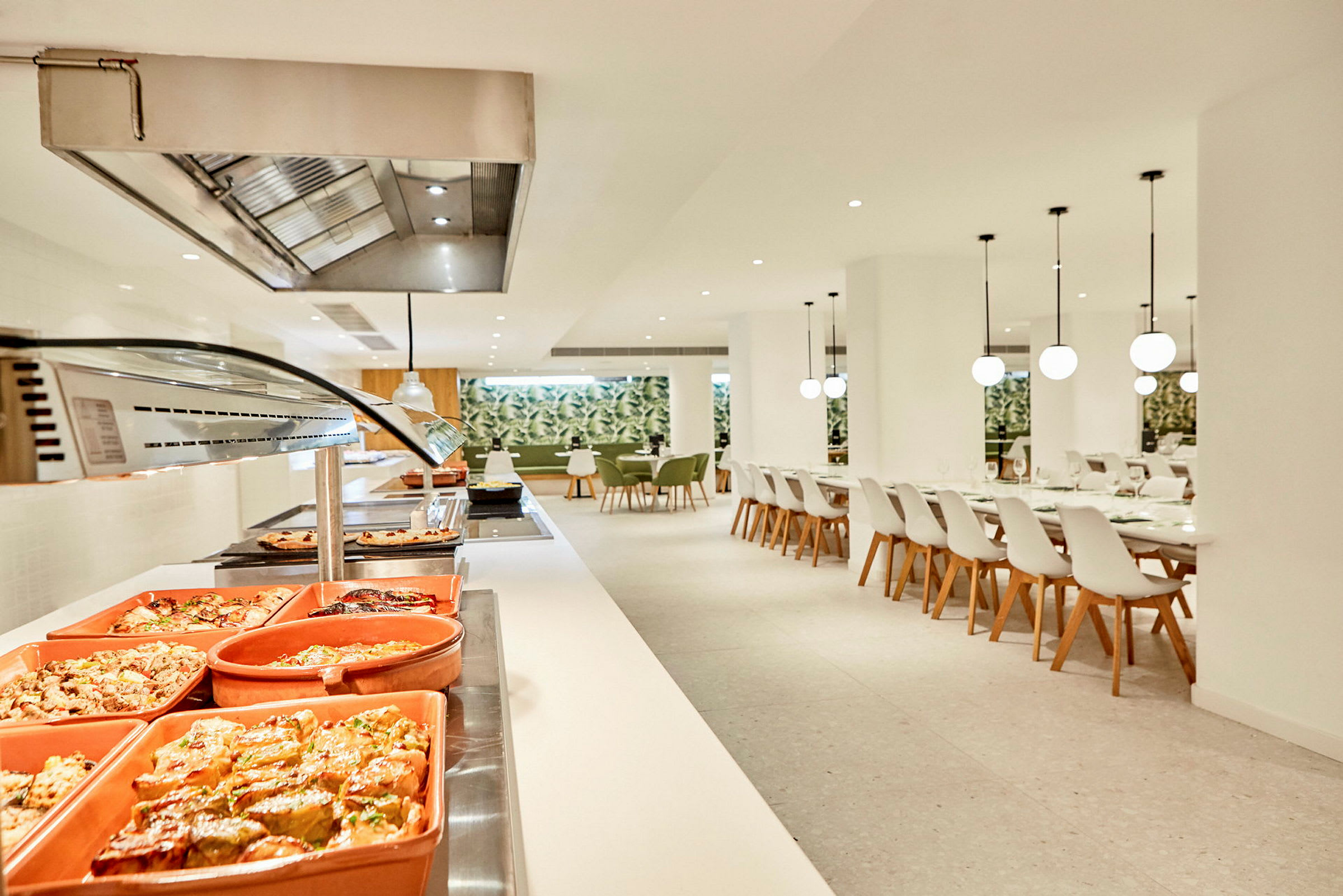 Buffet ja istumapaikat valoisassa ravintolassa. (Tekoälyn luoma teksti)