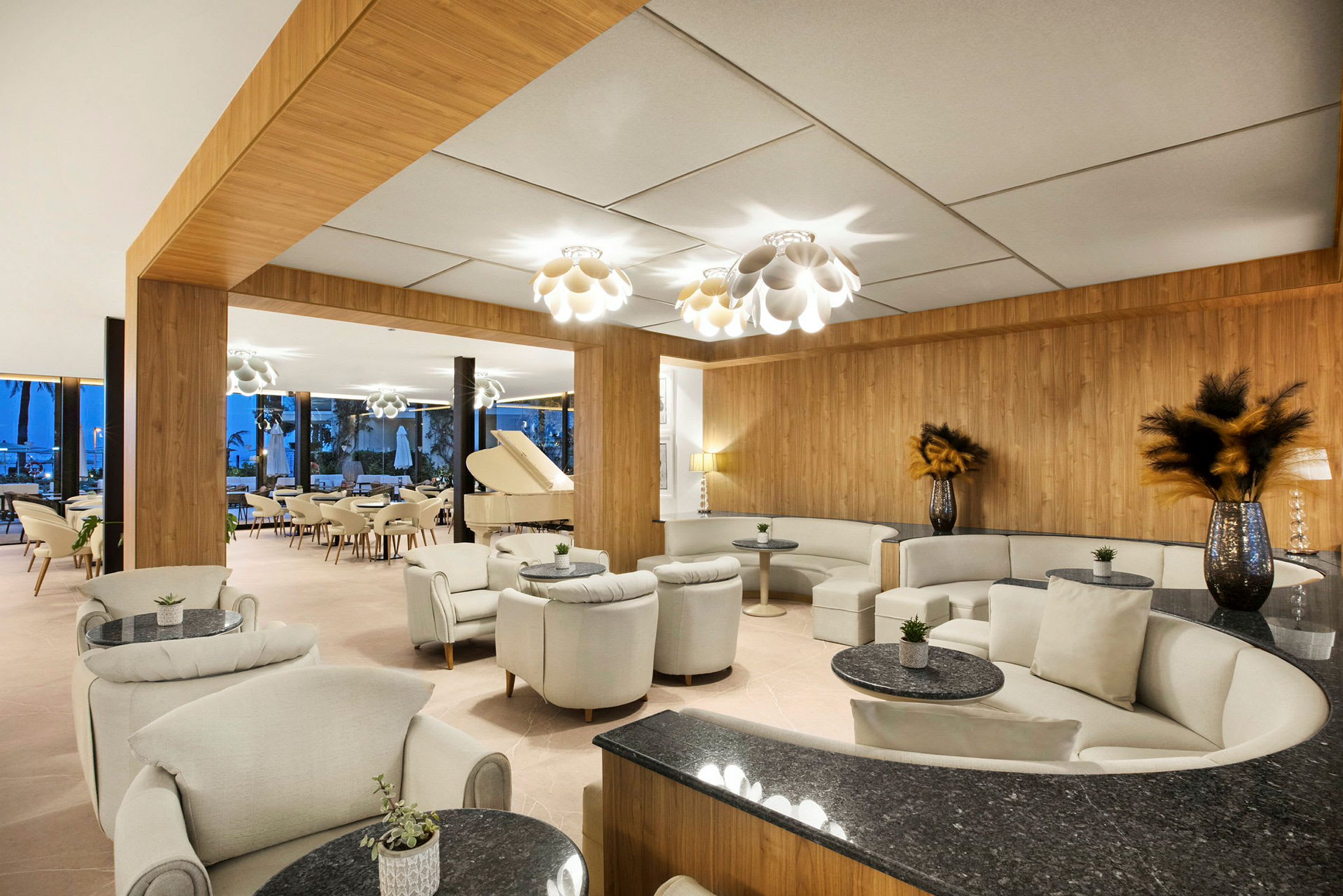 Tyylikäs hotelliaula, jossa on sohvaryhmiä, pieniä pöytiä ja valkoinen flyygeli. (Tekoälyn luoma teksti)